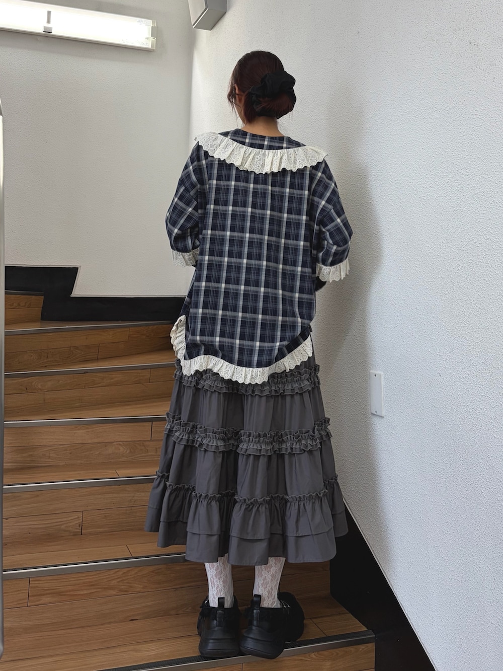 ブルー系のシャツ/ブラウス、グレー系のスカート、ブラック系のスニーカーを着用したレディースの夏コーディネートの2枚目の写真