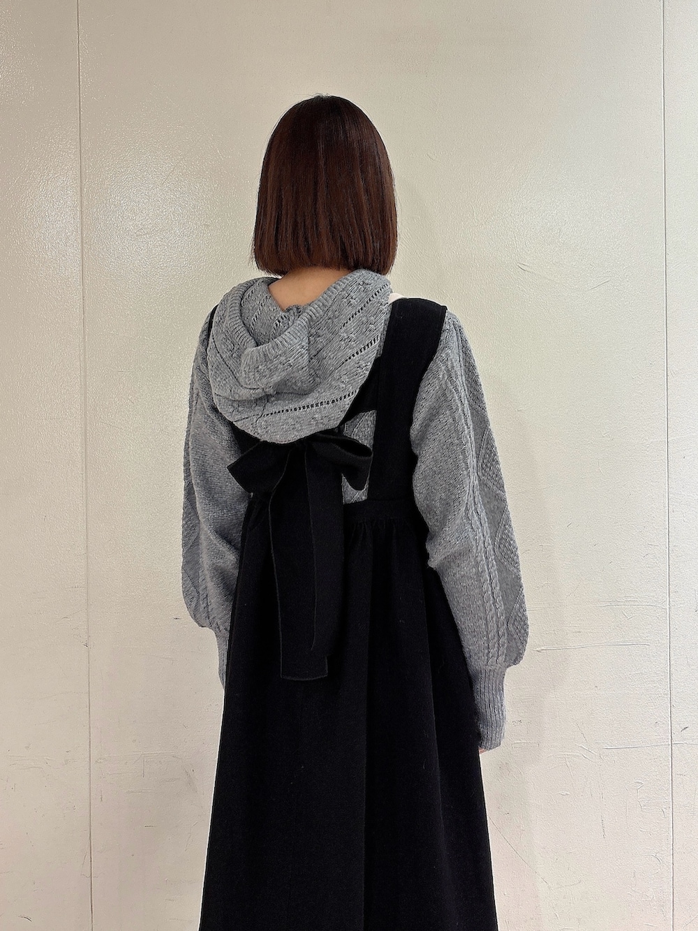 グレー系のニット/セーター、ブラック系のワンピース、ブラック系のブーツを着用したレディースの冬コーディネートの4枚目の写真