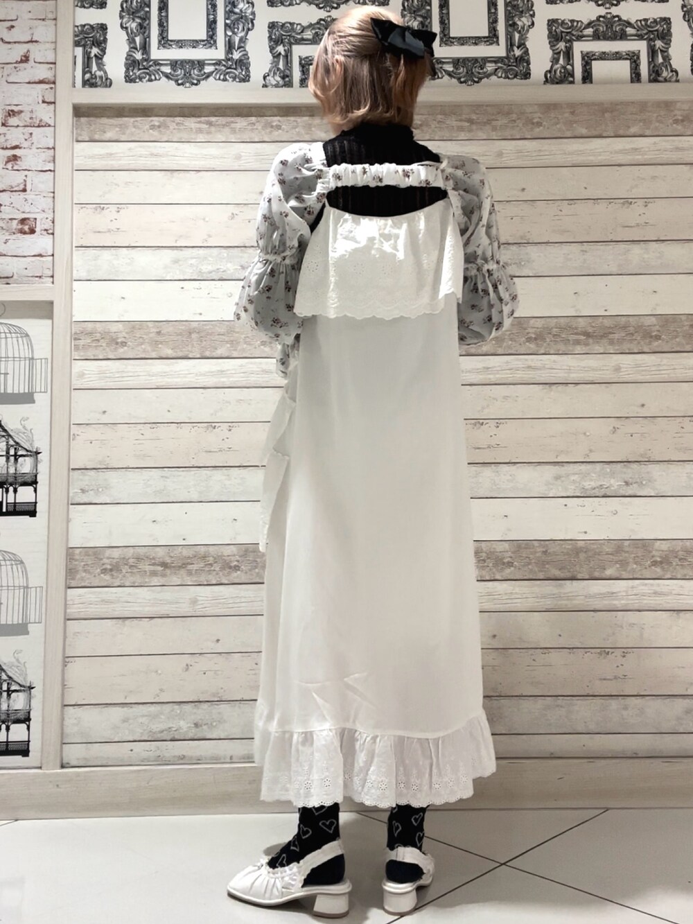 ホワイト系のワンピース、ホワイト系のカーディガン/ボレロ、ブラック系のTシャツ/カットソーを着用したレディースの春コーディネートの2枚目の写真