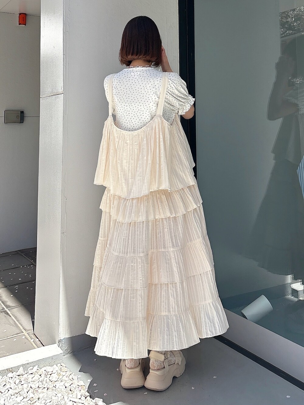 ホワイト系のワンピース、ブルー系のTシャツ/カットソー、ホワイト系のサンダルを着用したレディースの春コーディネートの2枚目の写真