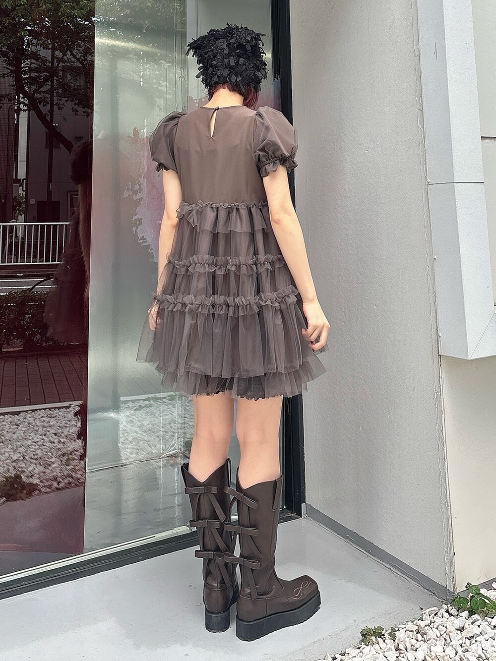 ブラウン系のワンピース、ブラウン系のブーツ、ブラック系のレギンス/スパッツを着用したレディースの夏コーディネートの2枚目の写真