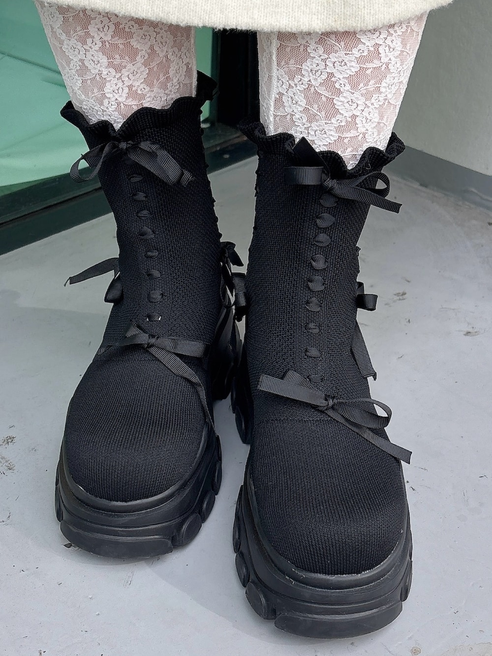 ベージュ系のムートンコート、ホワイト系のワンピース、ブラック系のブーツを着用したレディースの秋コーディネートの7枚目の写真