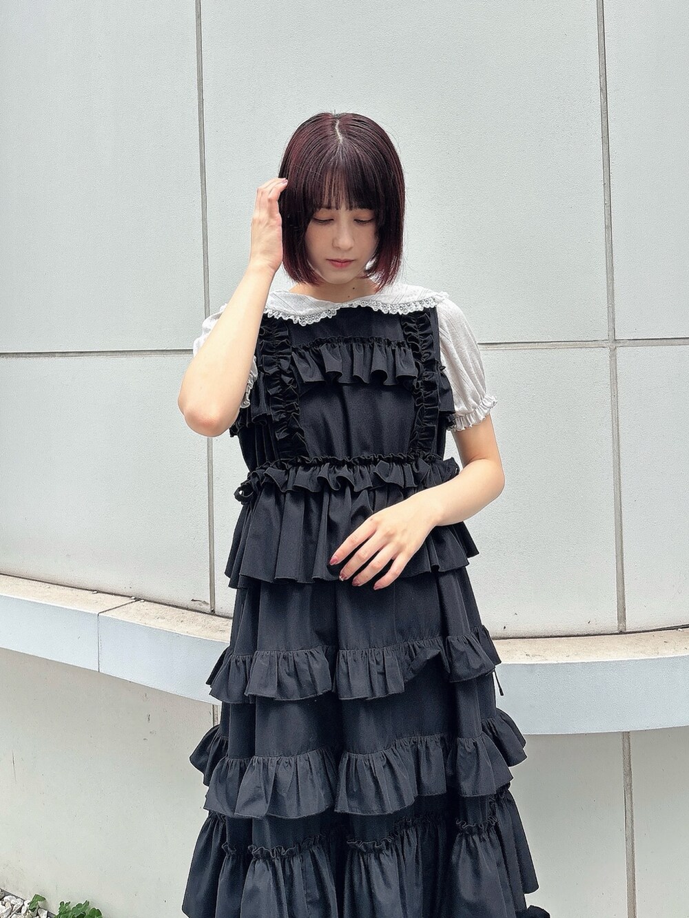 ブラック系のワンピース、グレー系のTシャツ/カットソー、ブラック系のサンダルを着用したレディースの夏コーディネートの3枚目の写真