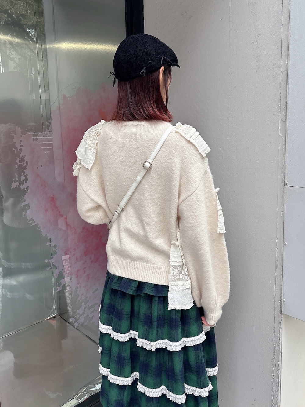 ホワイト系のニット/セーター、ホワイト系のショルダーバッグ、グリーン系のスカートを着用したレディースの秋コーディネートの4枚目の写真