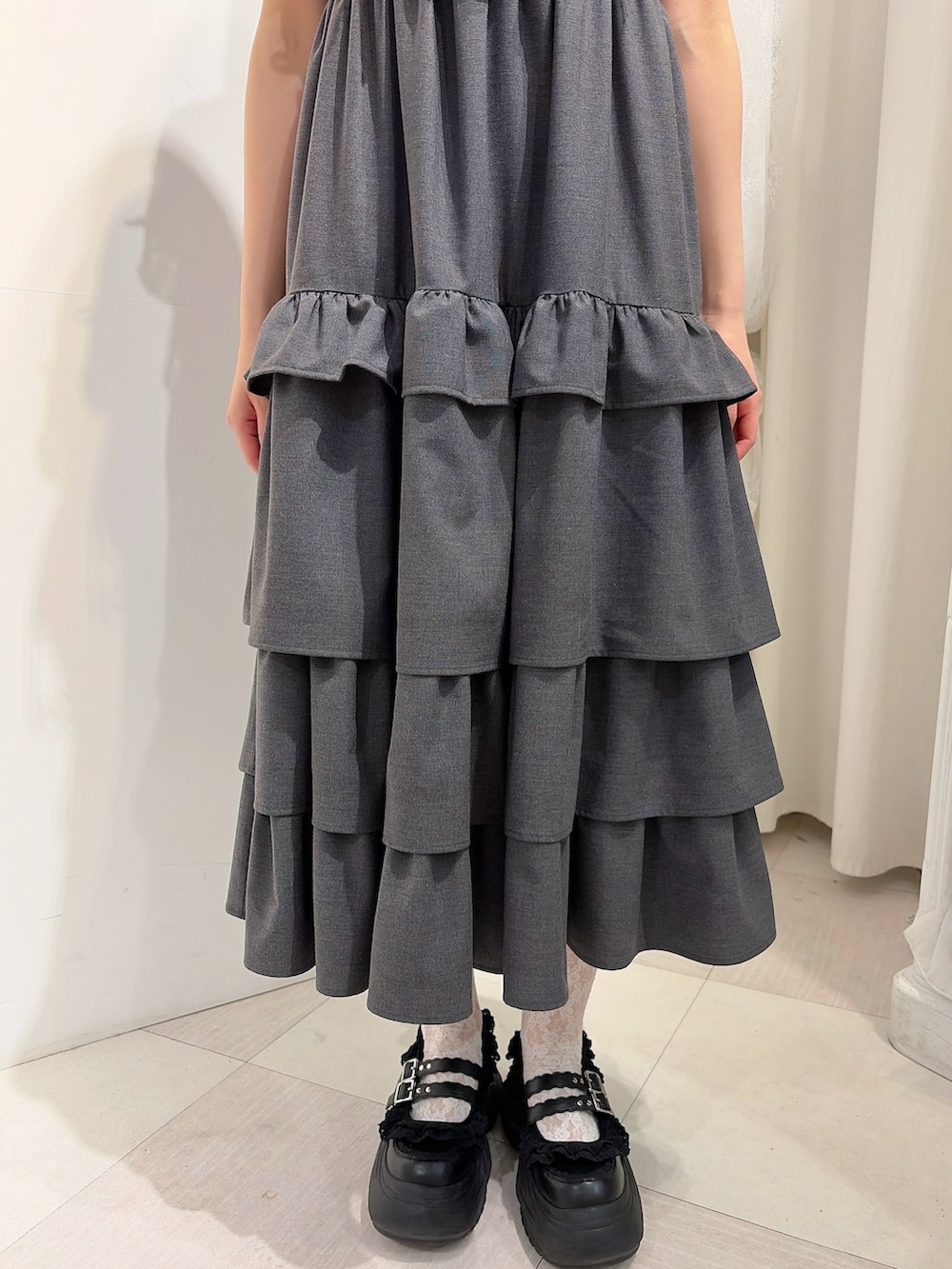 グレー系のワンピース、ホワイト系のTシャツ/カットソー、ブラック系のスニーカーを着用したレディースの春コーディネートの6枚目の写真