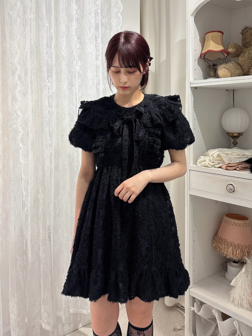 ブラック系のワンピース、ブラック系のサンダル、レッド系のハンドバッグを着用したレディースの夏コーディネートの3枚目の写真