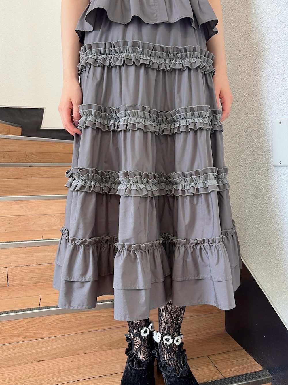 グレー系のシャツ/ブラウス、グレー系のスカート、ブラック系のパンプスを着用したレディースの夏コーディネートの6枚目の写真