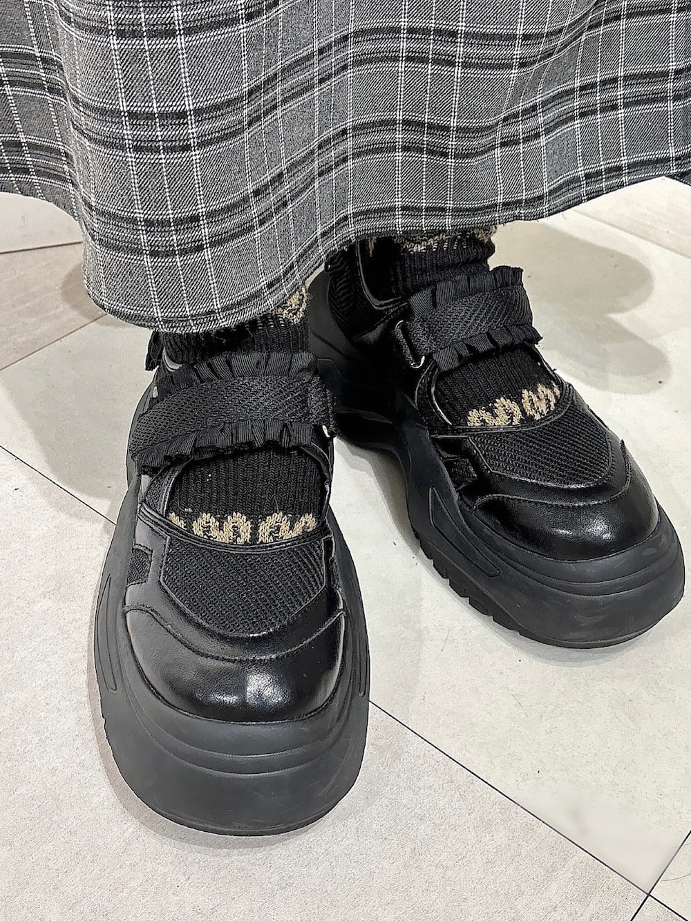 グレー系のスカート、ブラック系のスニーカー、グレー系のカーディガン/ボレロを着用したレディースの冬コーディネートの4枚目の写真