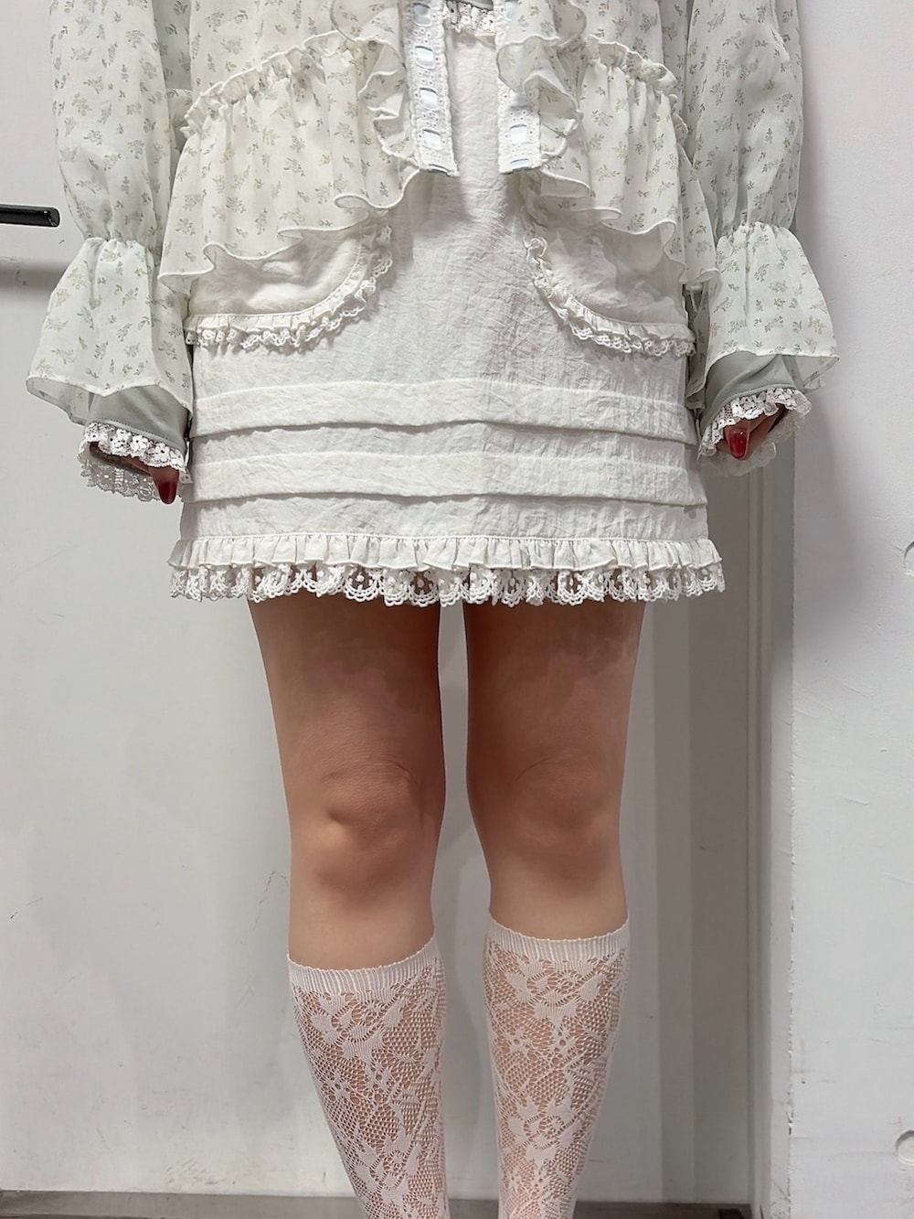 グリーン系のTシャツ/カットソー、ブルー系のカーディガン/ボレロ、ホワイト系のスカートを着用したレディースの冬コーディネートの6枚目の写真