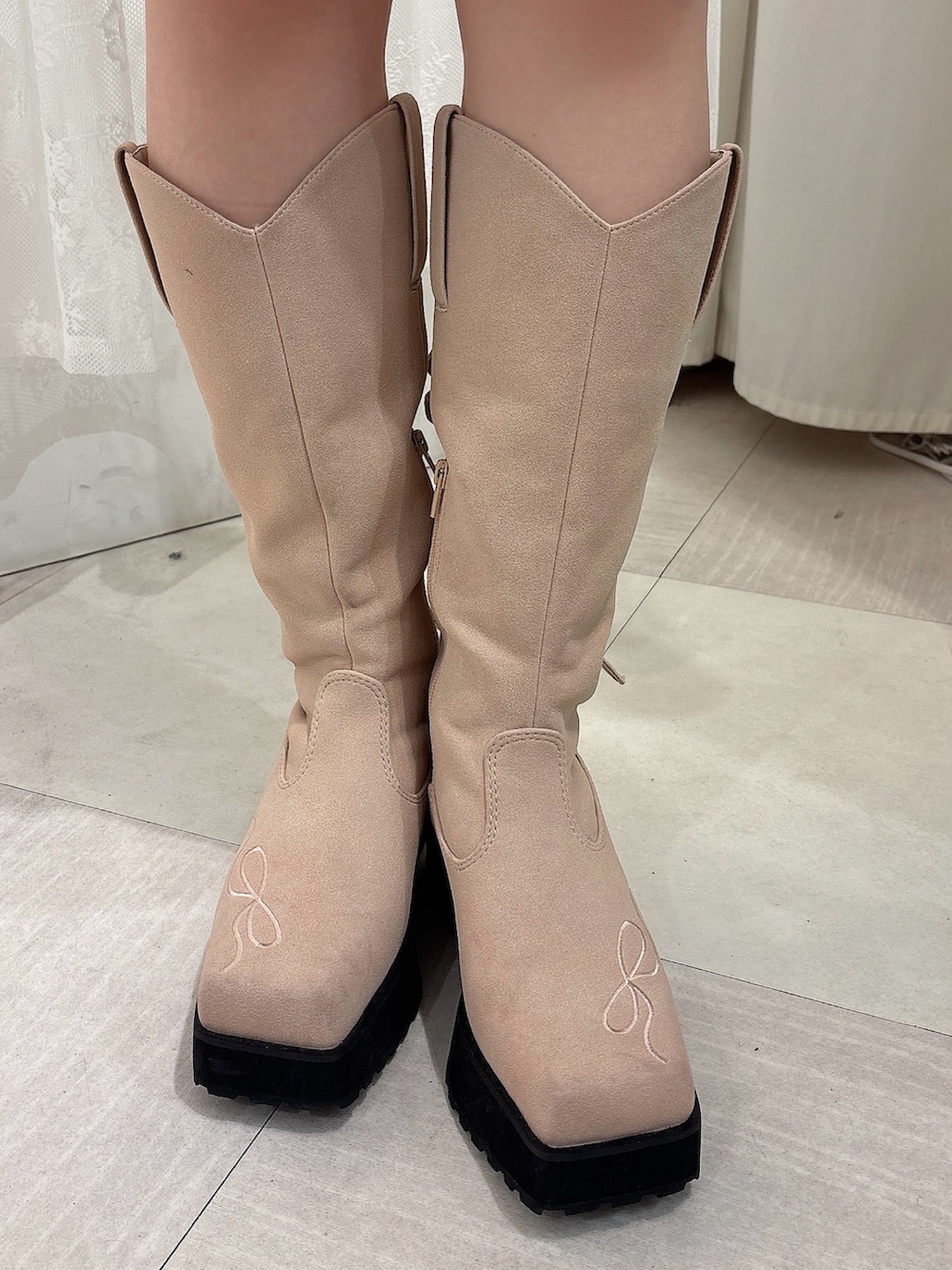 ピンク系のニット/セーター、ブラウン系のスカート、ピンク系のブーツを着用したレディースの秋コーディネートの6枚目の写真