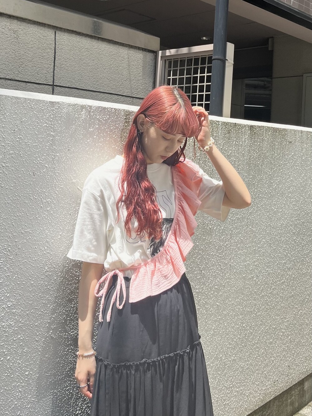 ブラック系のスカート、ブラック系のサンダル、ホワイト系のTシャツ/カットソーを着用したレディースの夏コーディネートの2枚目の写真