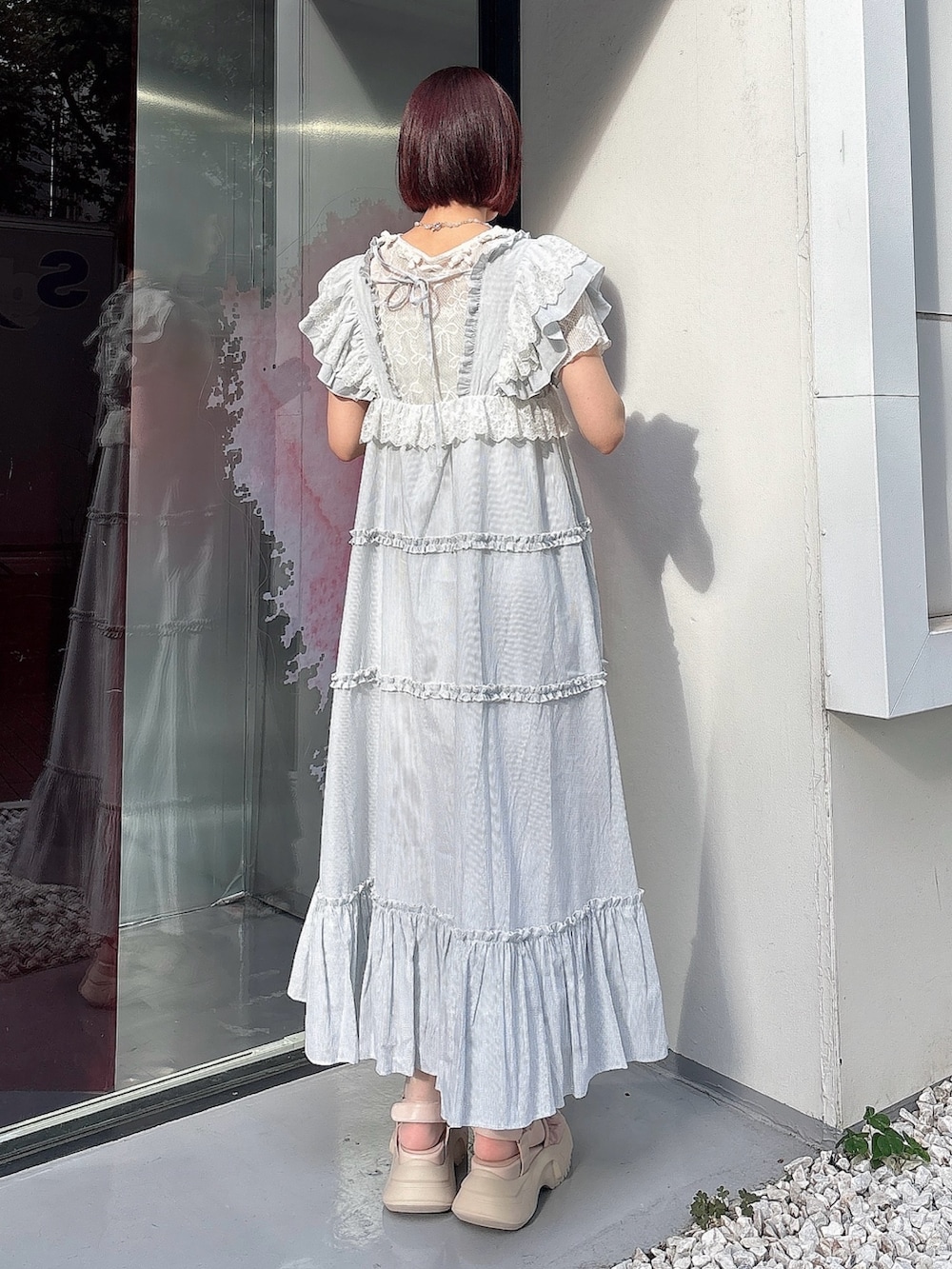 グリーン系のワンピース、ピンク系のサンダル、ホワイト系のTシャツ/カットソーを着用したレディースの夏コーディネートの2枚目の写真