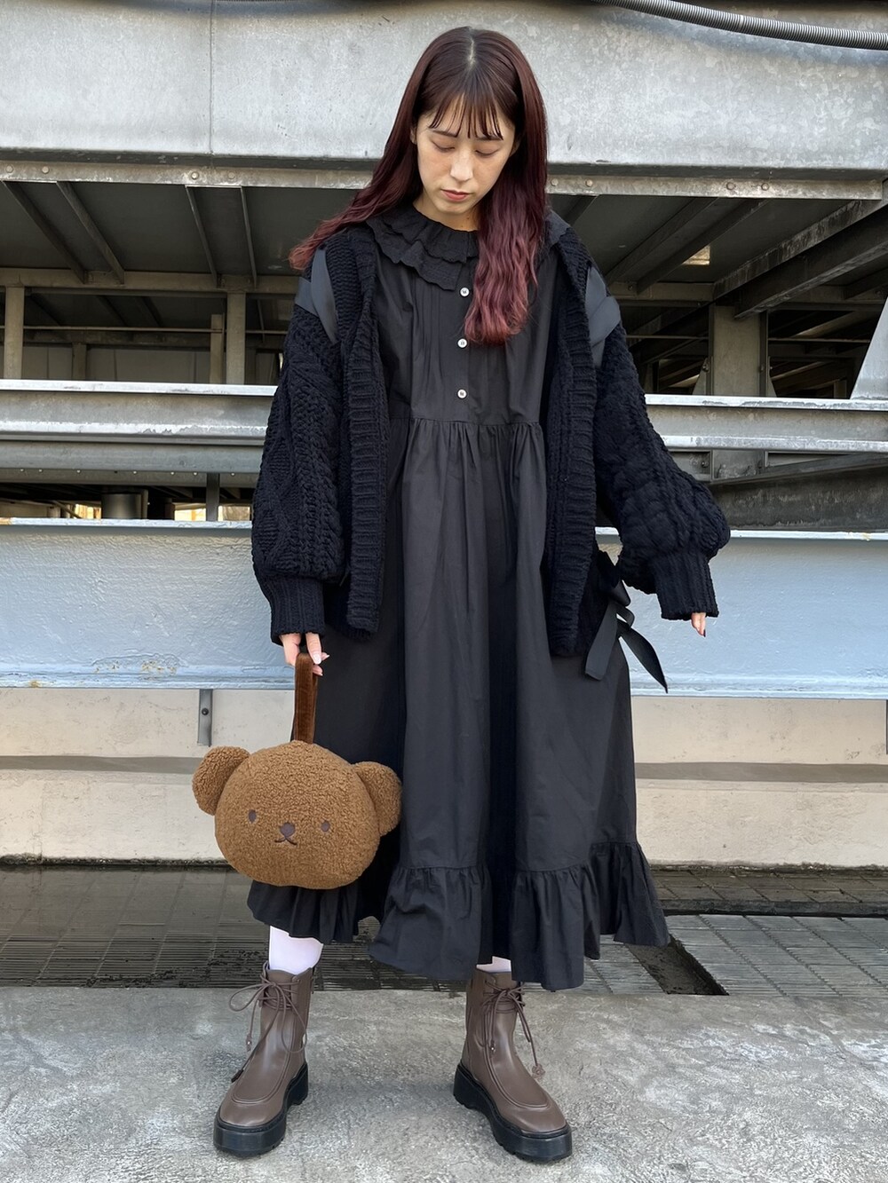 ブラック系のカーディガン/ボレロ、ブラウン系のブーツ、ブラック系のワンピースを着用したレディースの冬コーディネートの2枚目の写真