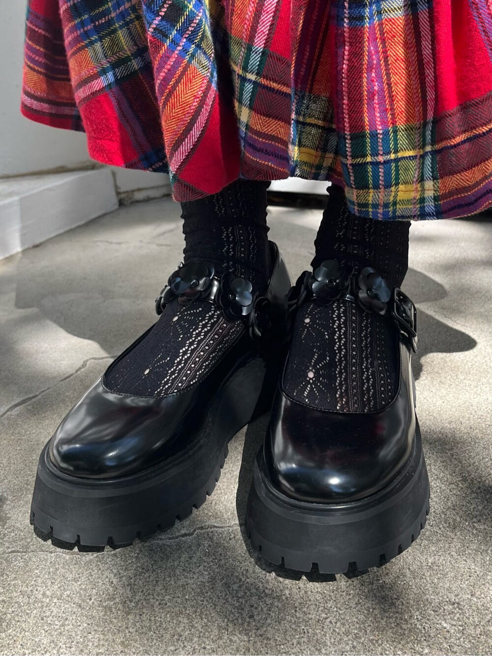 ブラック系のローファー、ホワイト系のニット/セーター、レッド系のスカートを着用したレディースの秋コーディネートの3枚目の写真