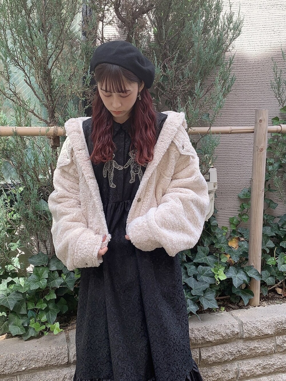 ブラック系のワンピース、ホワイト系のブーツ、ホワイト系のカバーオールを着用したレディースの秋コーディネートの3枚目の写真