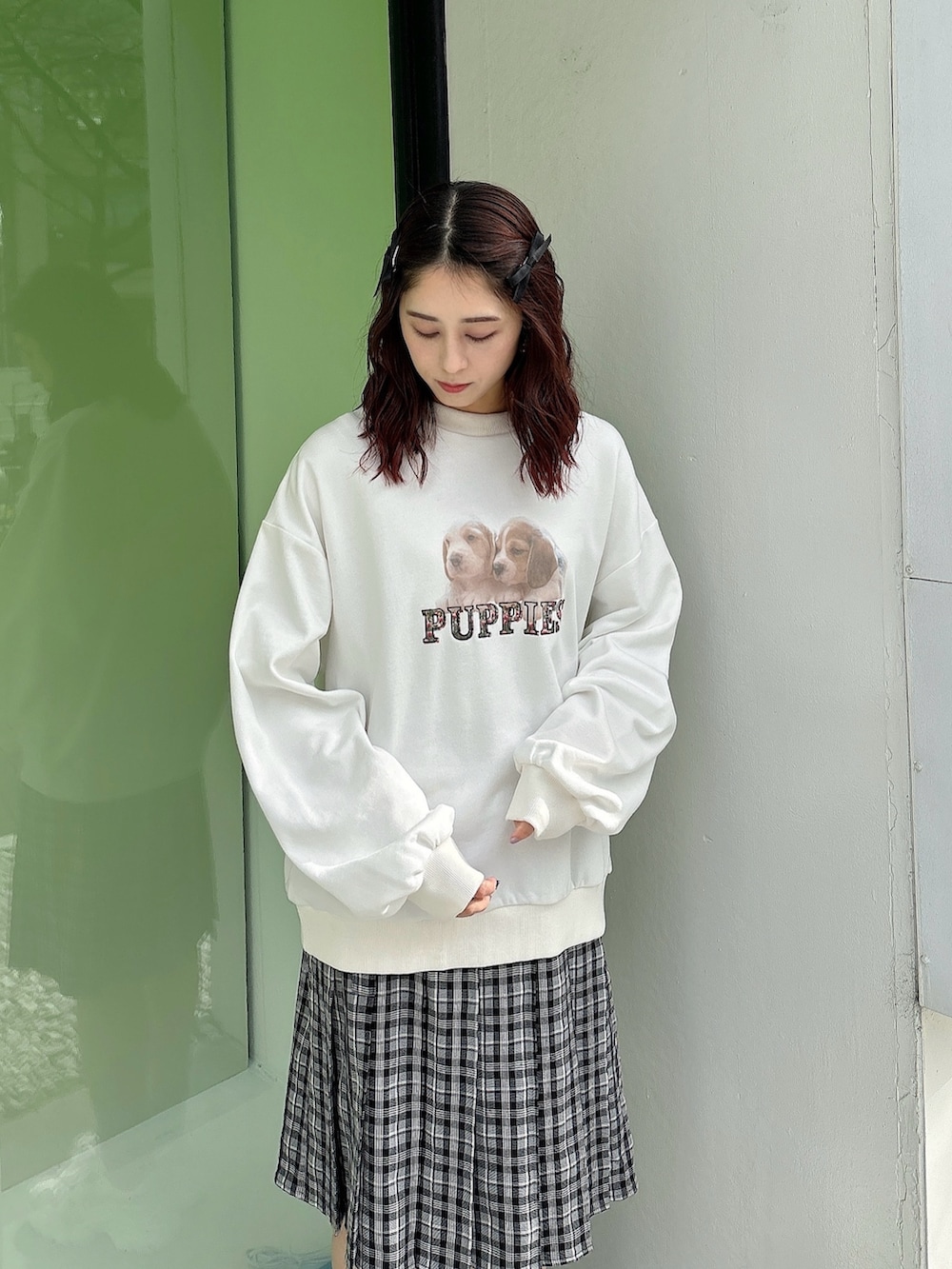 ホワイト系のスウェット、ブラック系のスカート、ホワイト系のスニーカーを着用したレディースの冬コーディネートの2枚目の写真