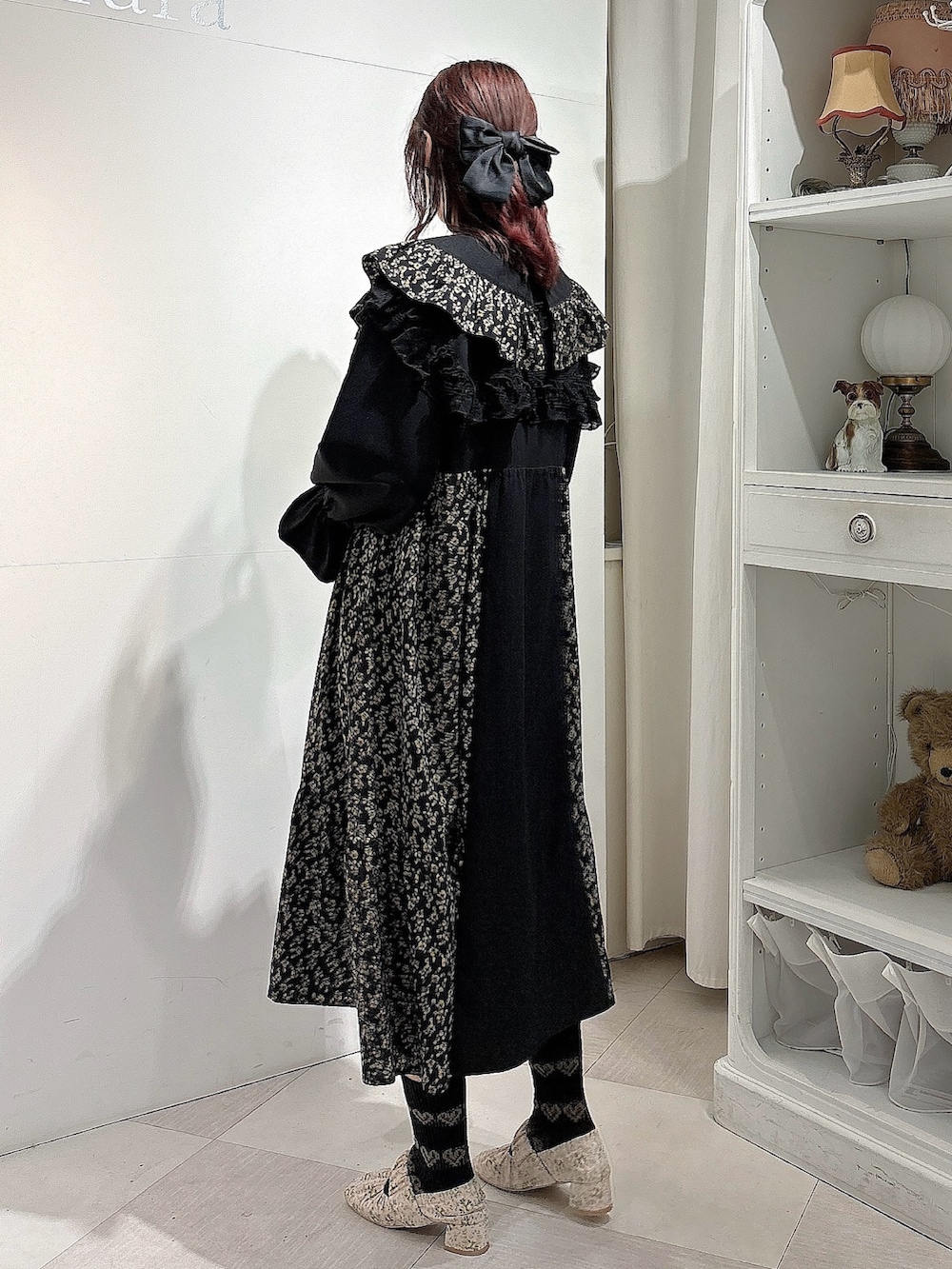 ピンク系のパンプス、ブラック系のワンピース、ブラック系の付け襟を着用したレディースの冬コーディネートの2枚目の写真