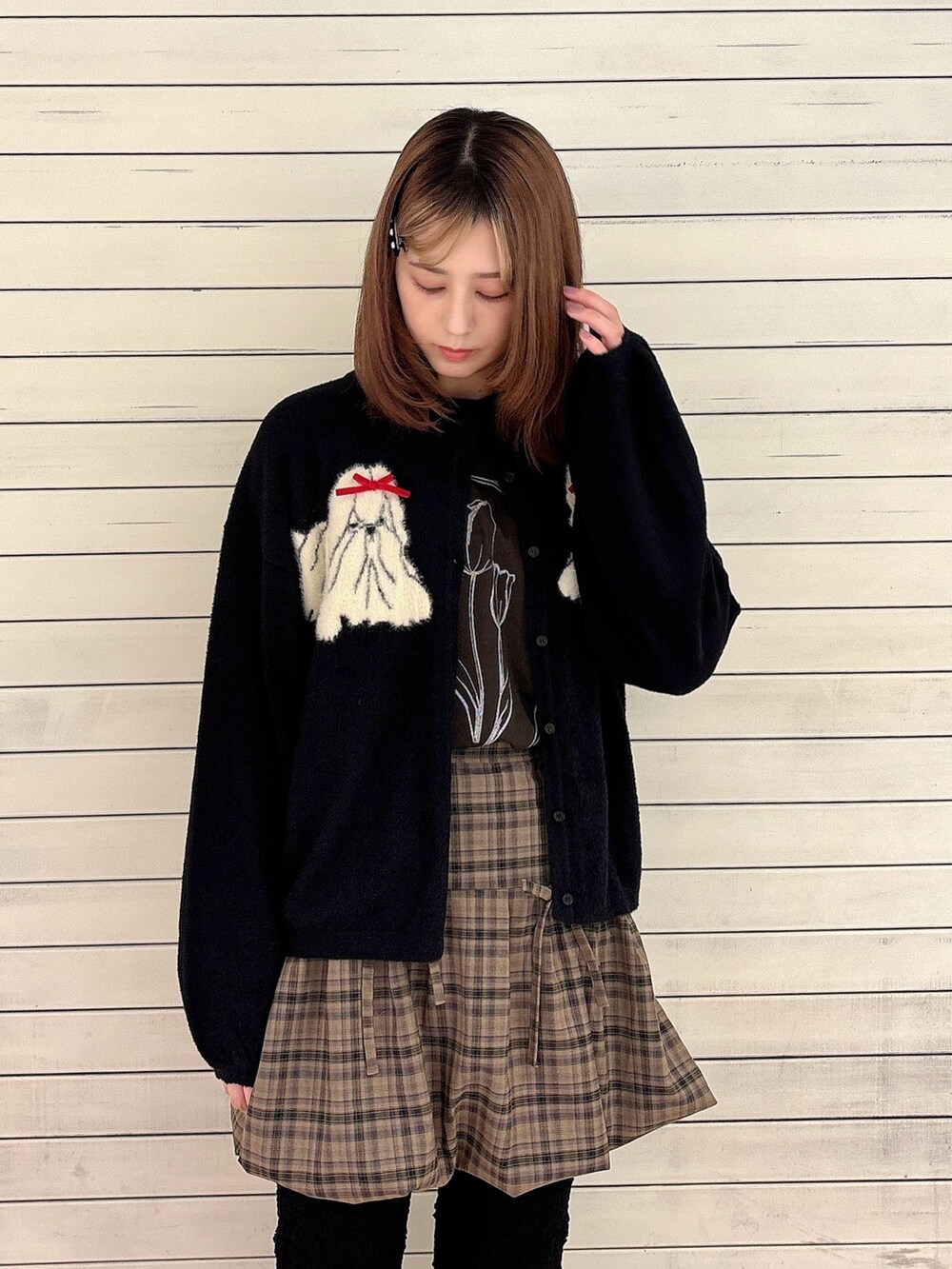 ブラック系のカーディガン/ボレロ、ブラウン系のスカート、ホワイト系のスラックスを着用したレディースの秋コーディネートの3枚目の写真