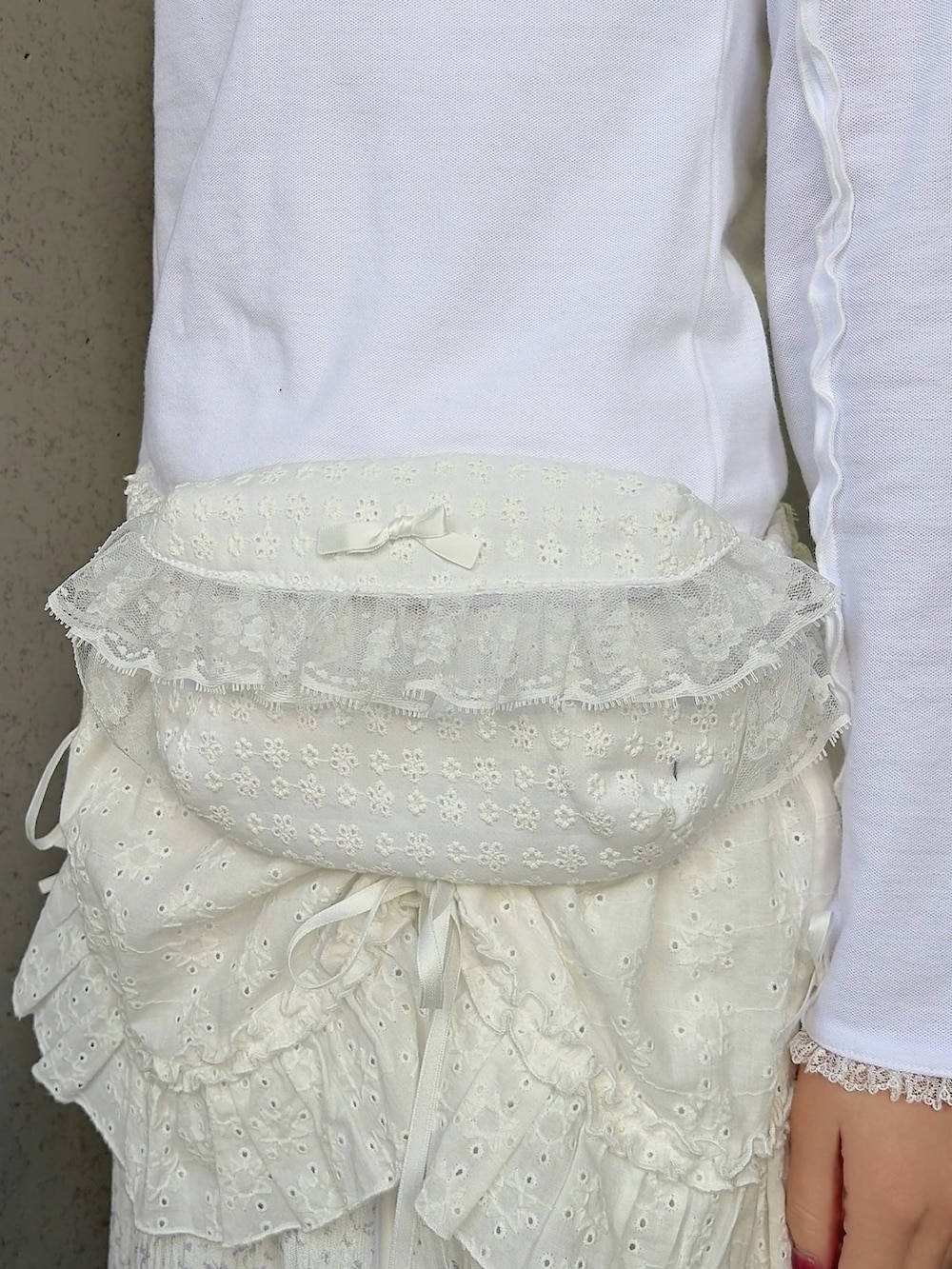 ホワイト系のポロシャツ、ホワイト系のボディバッグ/ウエストポーチ、ホワイト系のスカートを着用したレディースの冬コーディネートの6枚目の写真