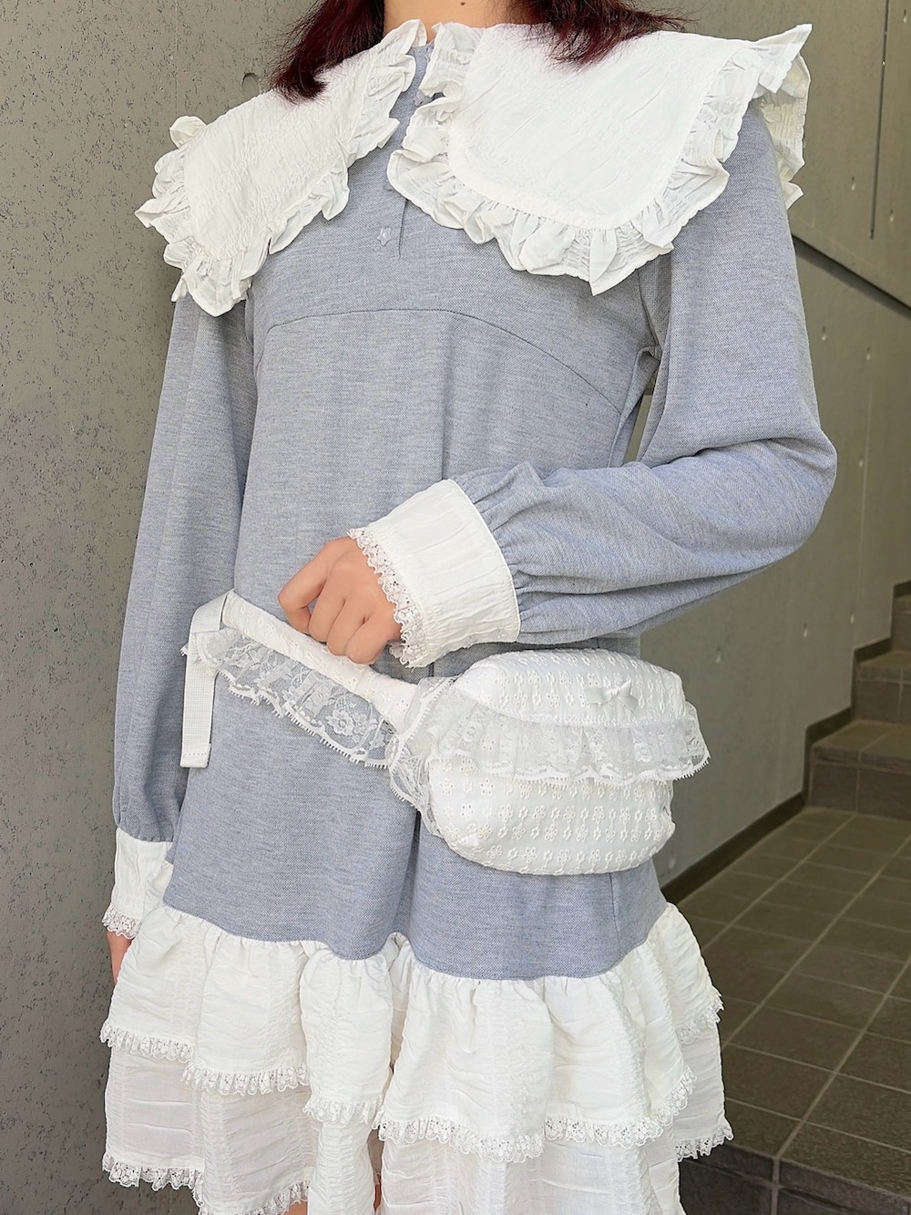 グレー系のワンピース、ブラック系のスニーカー、ホワイト系のボディバッグ/ウエストポーチを着用したレディースの冬コーディネートの6枚目の写真