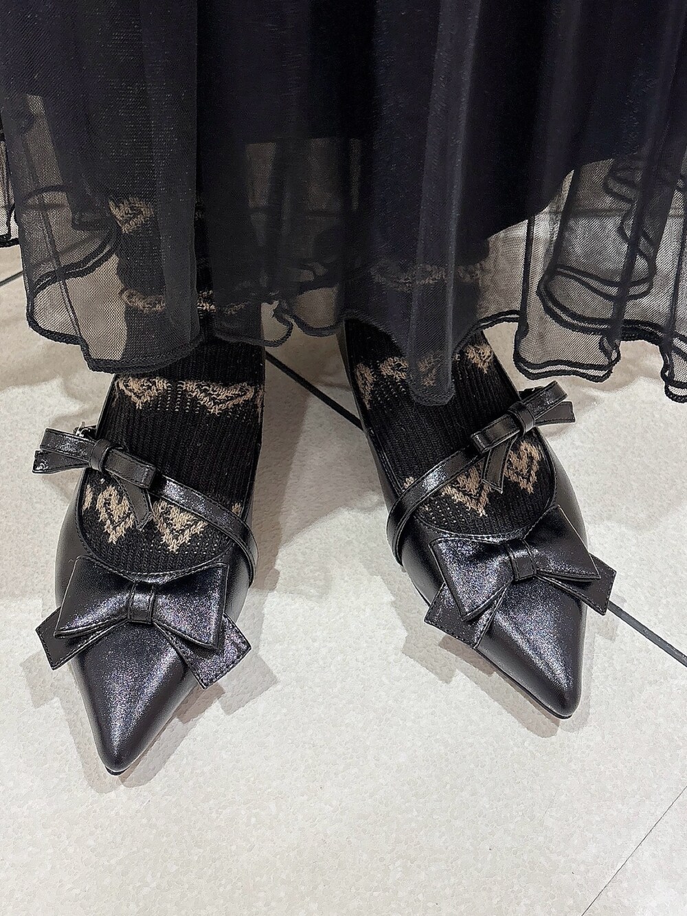 ピンク系のブルゾン、ホワイト系のニット/セーター、ブラック系のスカートを着用したレディースの冬コーディネートの9枚目の写真