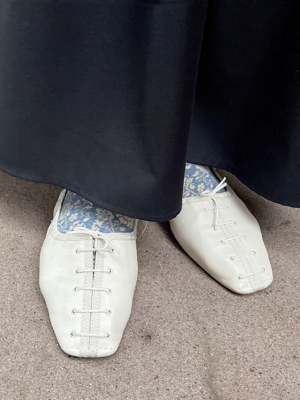 ホワイト系のパンプス、ブラック系のスカート、ブラック系のTシャツ/カットソーを着用したレディースの春コーディネートの4枚目の写真