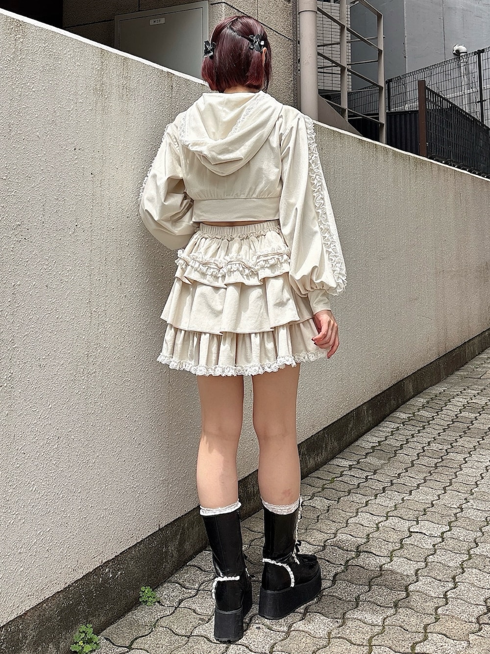 ホワイト系のパーカー、ホワイト系のスカート、ブラック系のブーツを着用したレディースの夏コーディネートの2枚目の写真