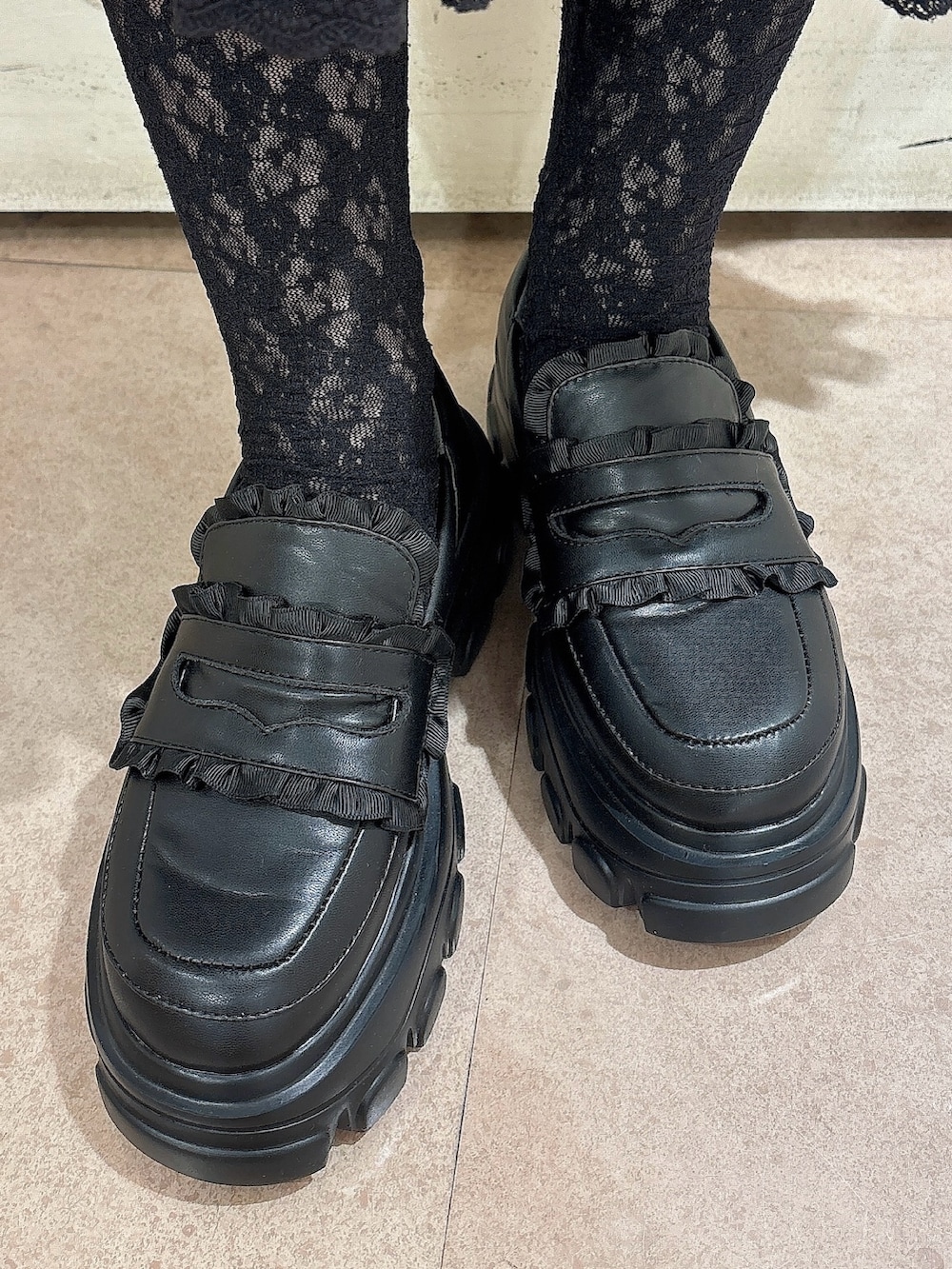 グレー系のニット/セーター、ブラック系のスカート、ホワイト系のスカートを着用したレディースの秋コーディネートの7枚目の写真