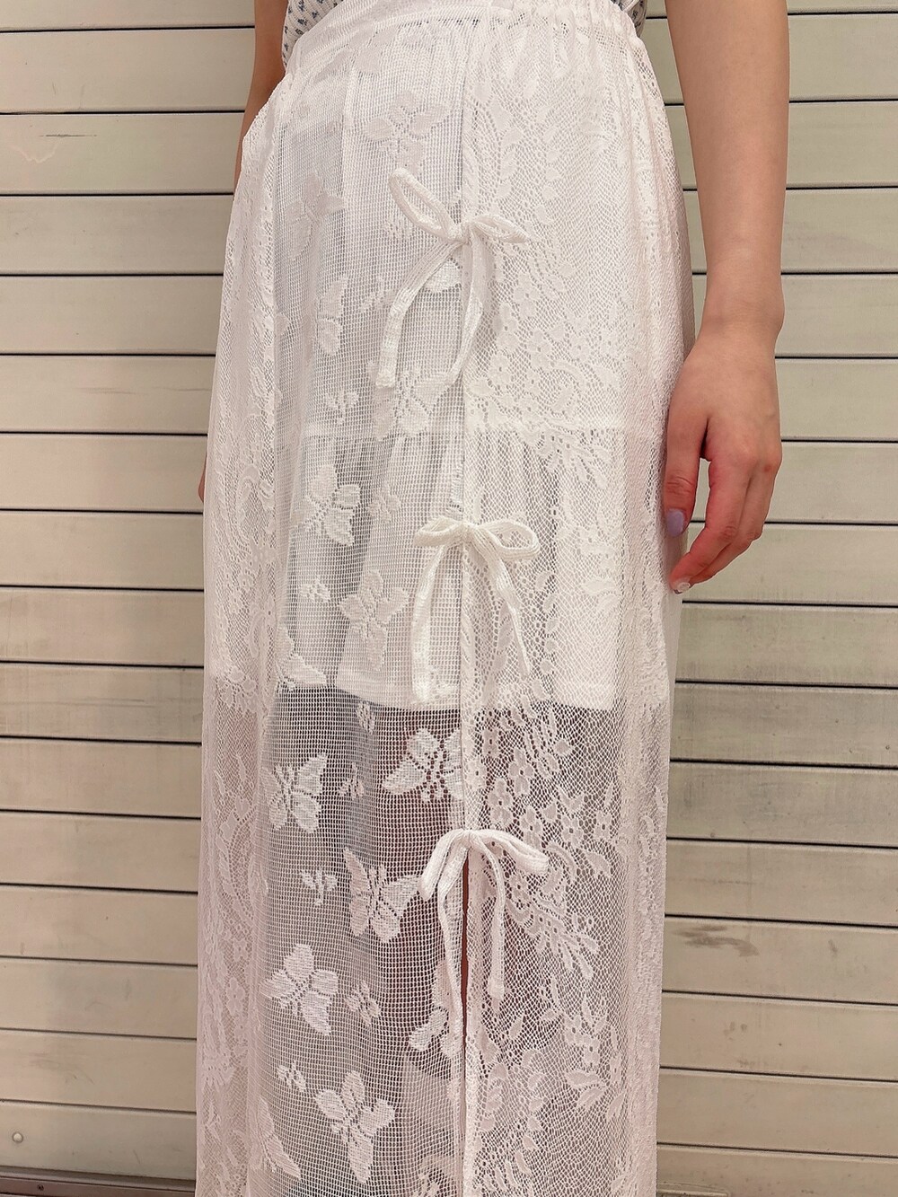 ホワイト系のスカート、ホワイト系のスニーカー、ブルー系のTシャツ/カットソーを着用したレディースの春コーディネートの6枚目の写真