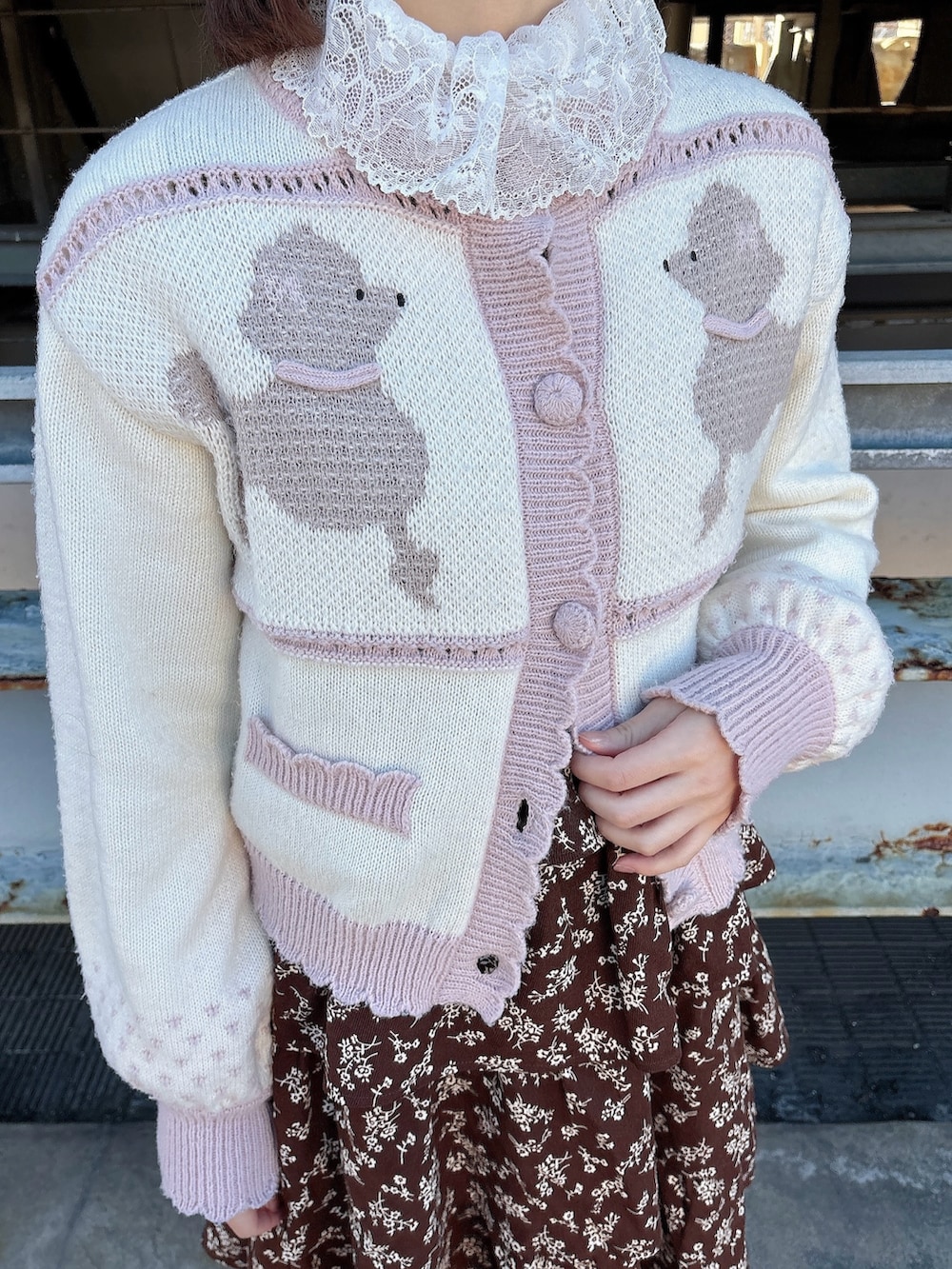 ブラウン系のワンピース、ブラック系のパンプス、ピンク系のカーディガン/ボレロを着用したレディースの冬コーディネートの8枚目の写真