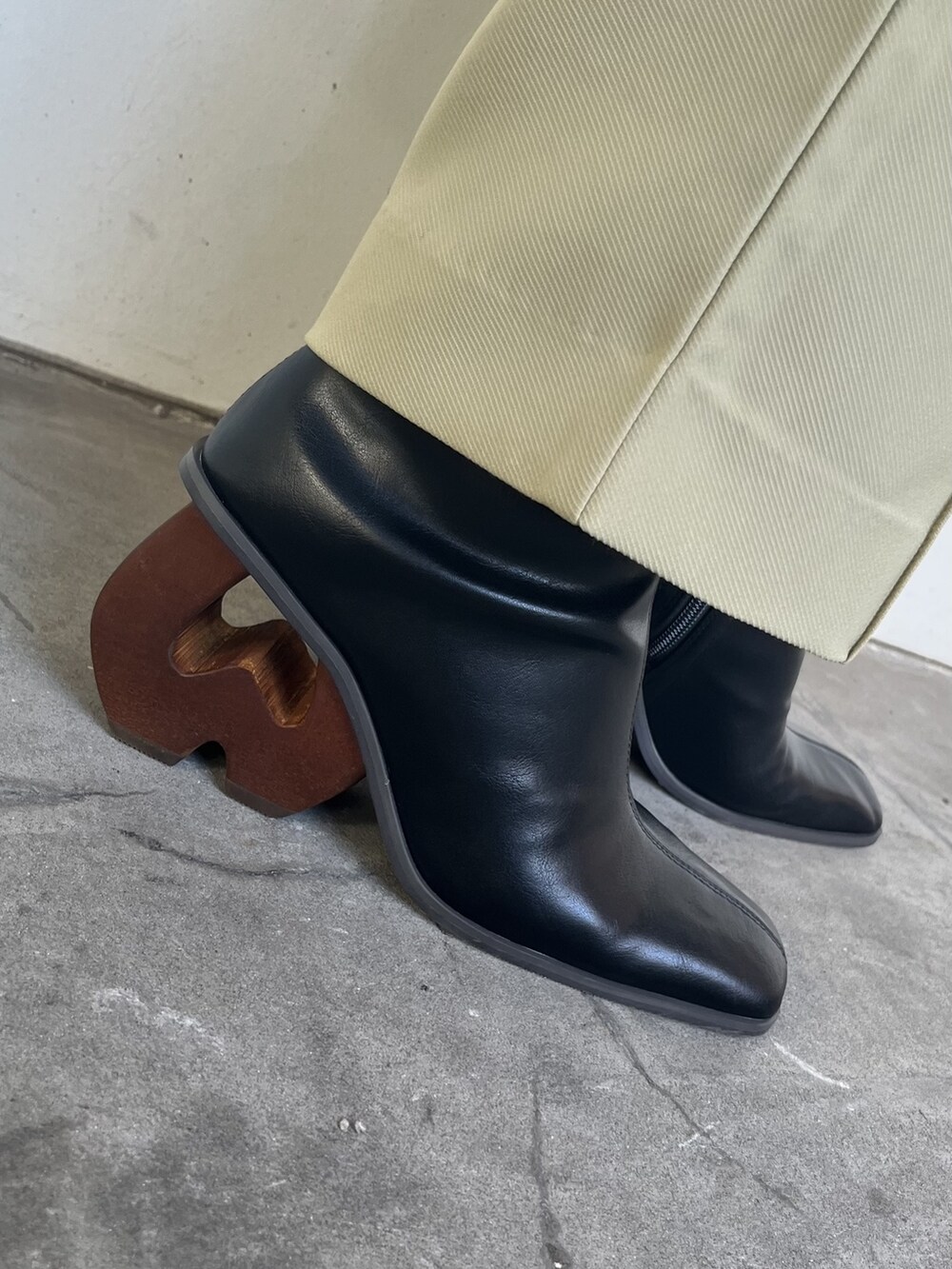 ブラック系のブーツ、ホワイト系のカーディガン/ボレロ、ブラック系のニット/セーターを着用したレディースの夏コーディネートの2枚目の写真