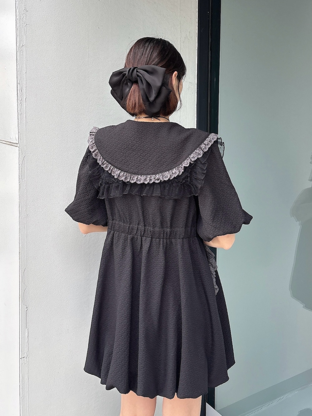 ブラック系のワンピース、ブラック系のスニーカー、ブラック系の付け襟を着用したレディースの春コーディネートの4枚目の写真