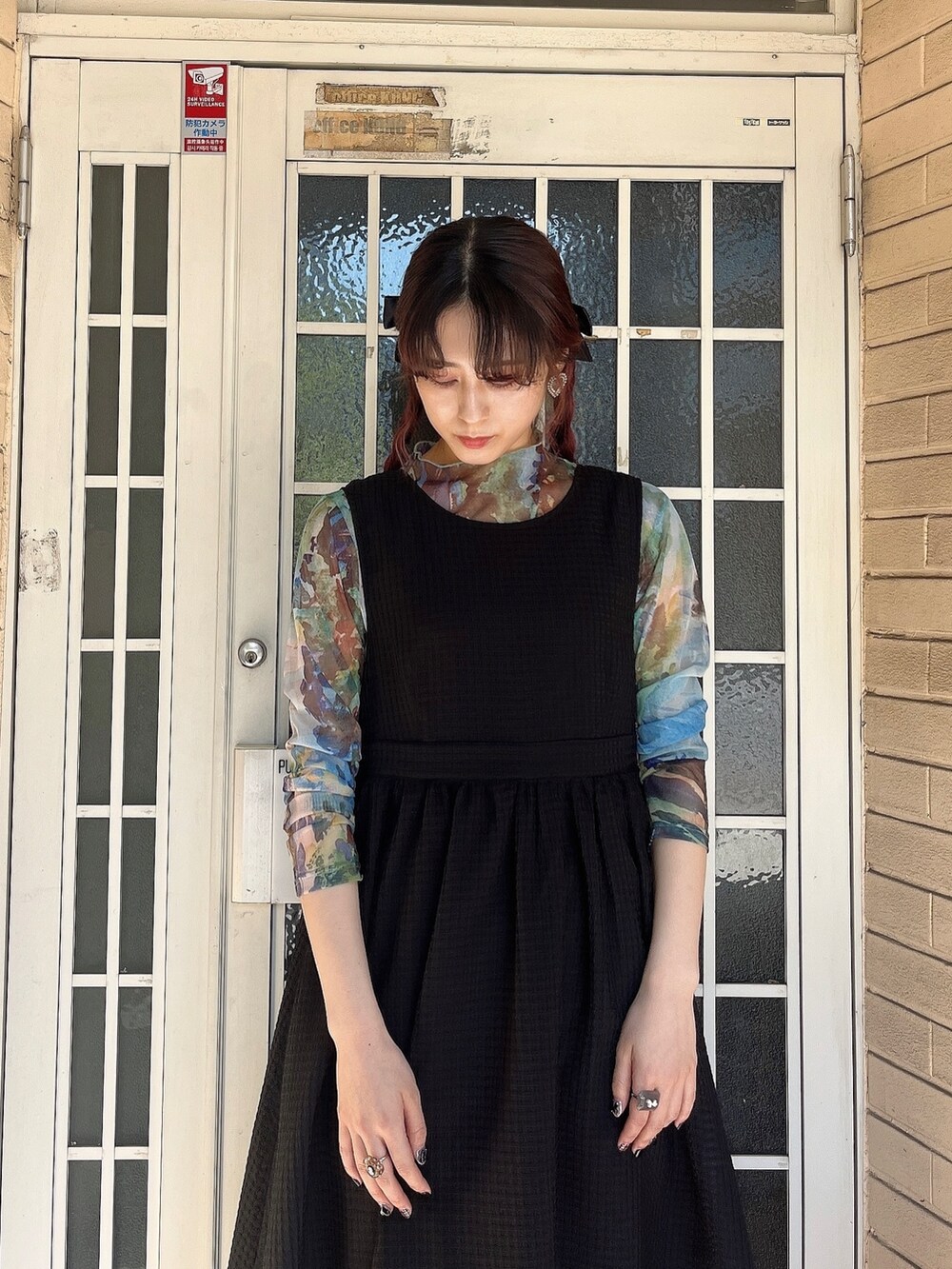 ブラック系のサンダル、グリーン系のTシャツ/カットソー、ブラック系のワンピースを着用したレディースの春コーディネートの2枚目の写真