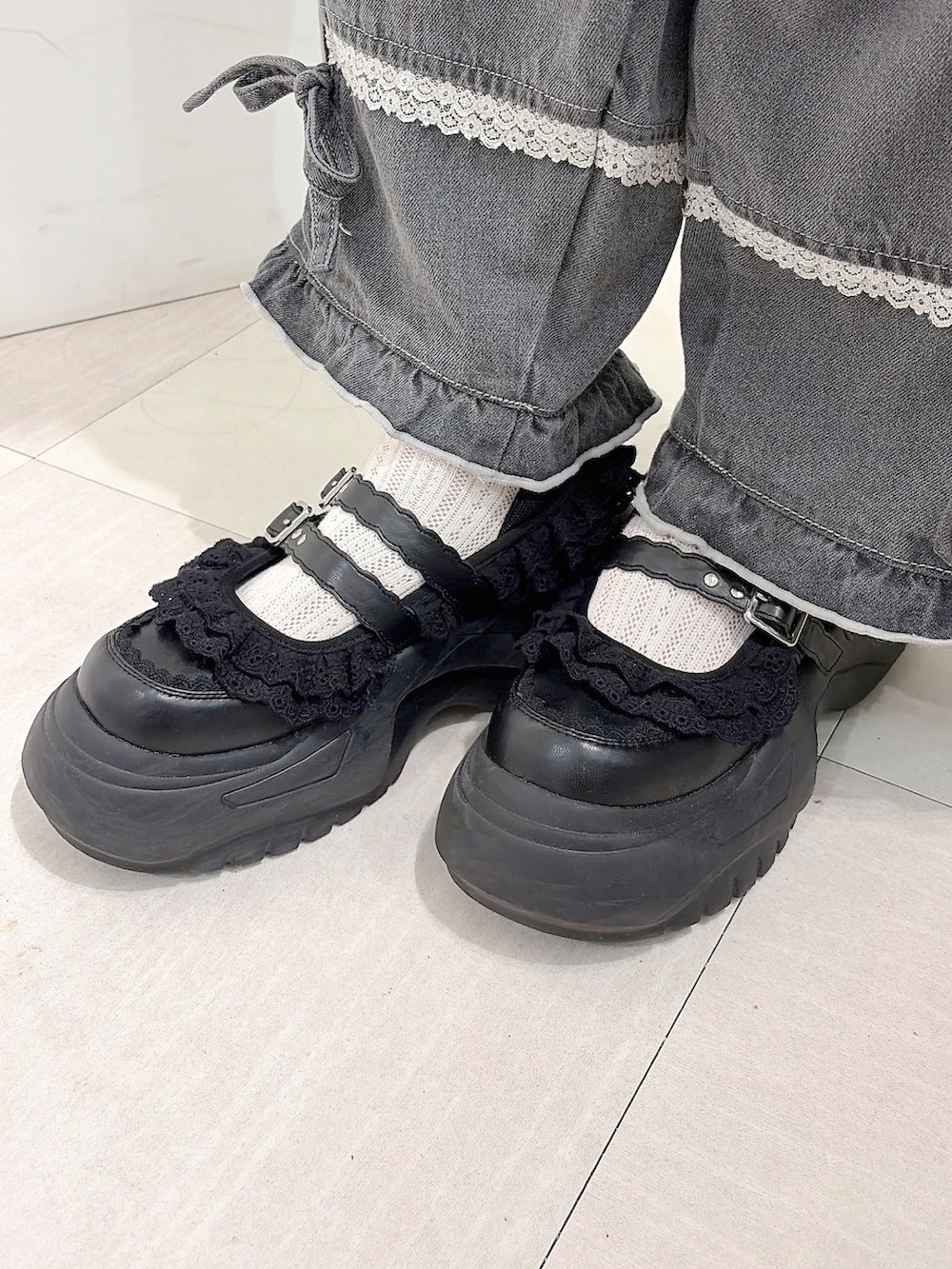 グレー系のデニムパンツ、ホワイト系のスニーカー、グリーン系のワンピースを着用したレディースの夏コーディネートの9枚目の写真