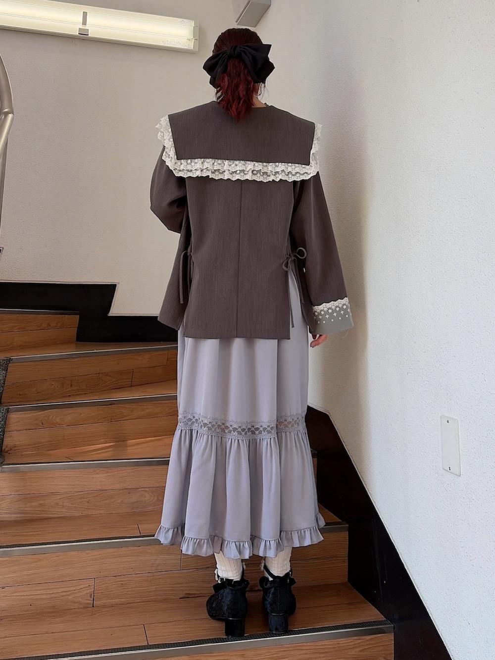 ブルー系のワンピース、ブラック系のパンプス、グレー系のテーラードジャケットを着用したレディースの春コーディネートの2枚目の写真