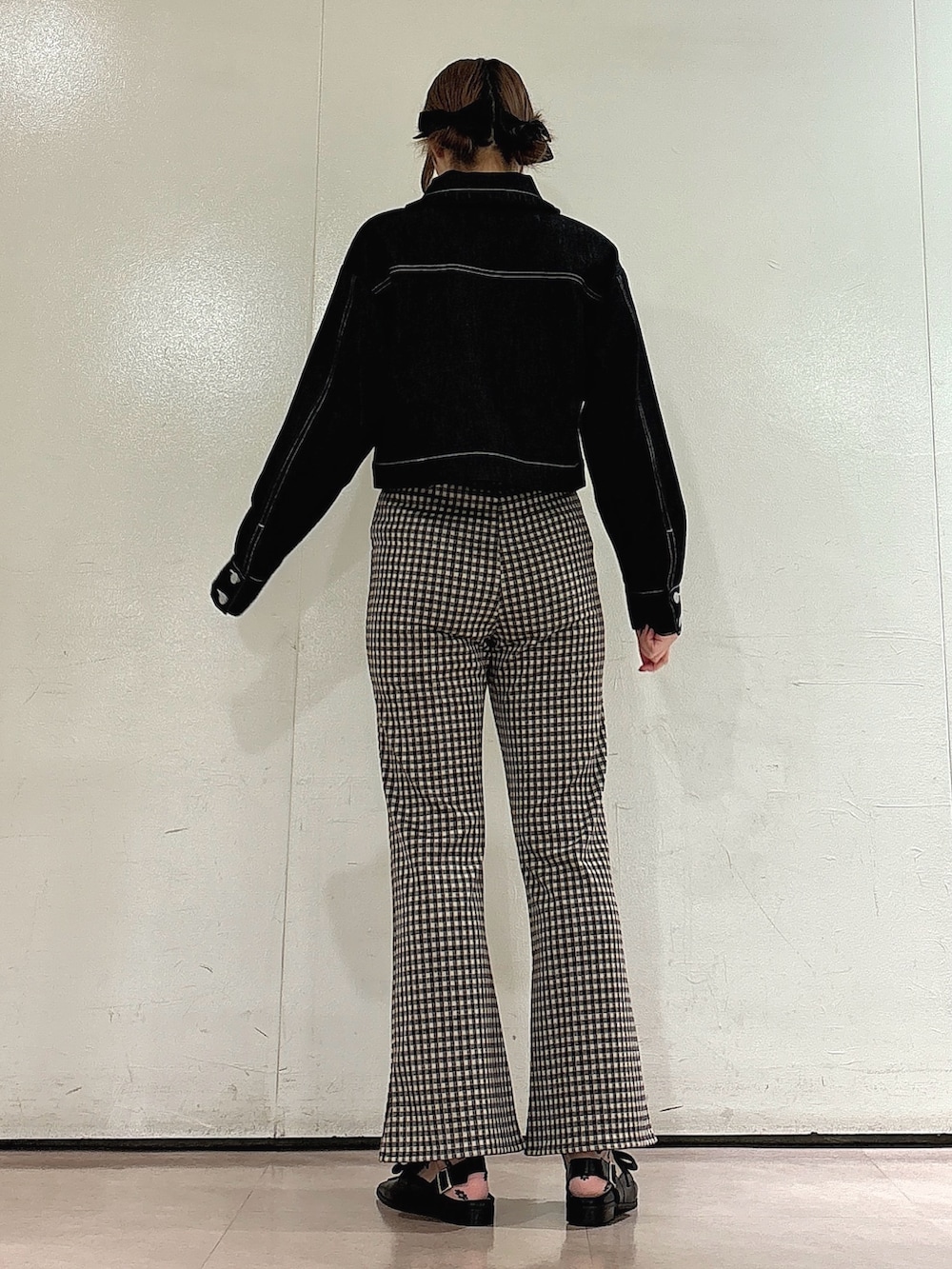 ブラック系のデニムジャケット、ブラック系のTシャツ/カットソー、ブラウン系のスラックスを着用したレディースの夏コーディネートの2枚目の写真