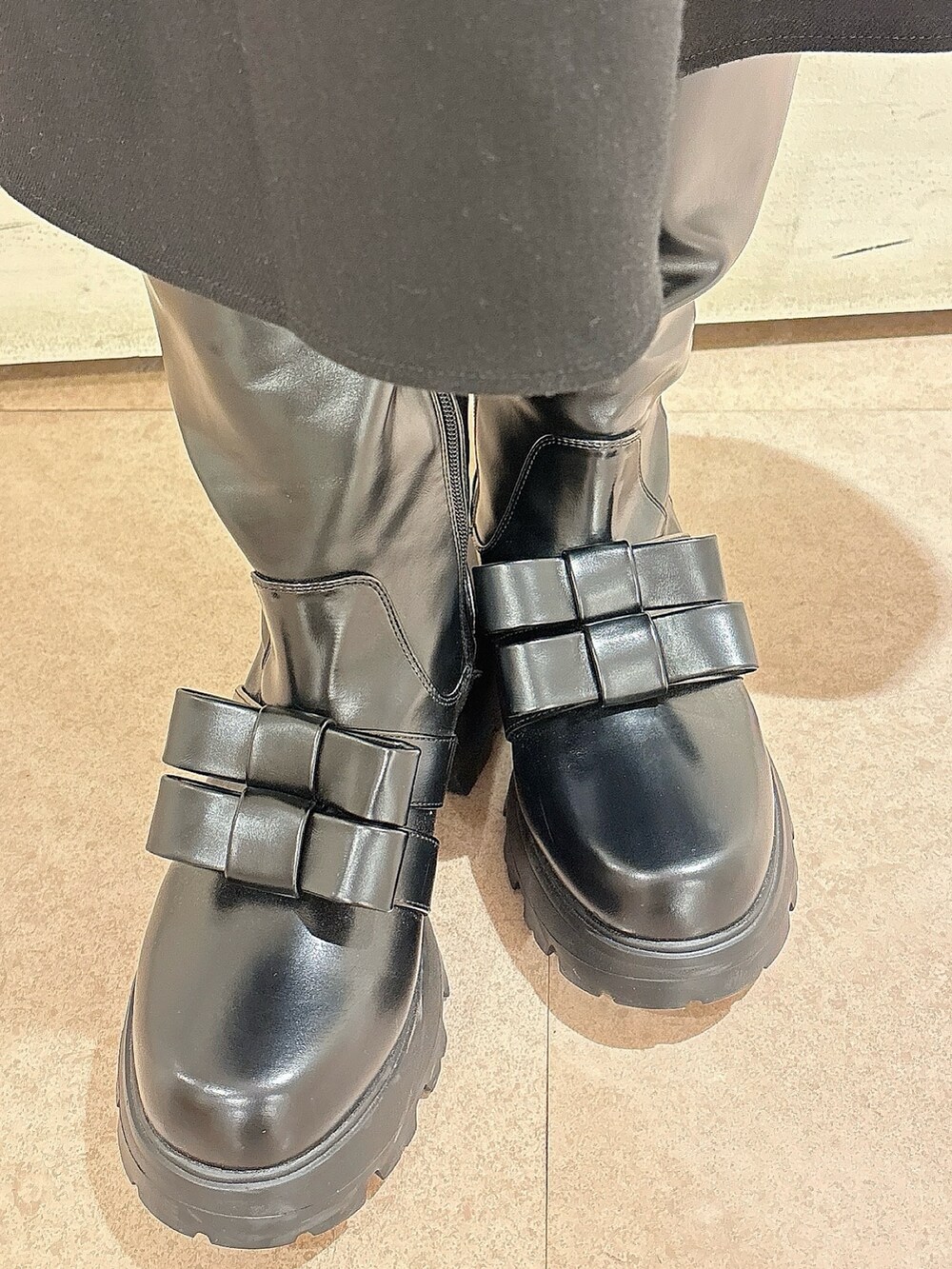 グレー系のニット/セーター、ブラック系のワンピース、ブラック系のブーツを着用したレディースの冬コーディネートの7枚目の写真