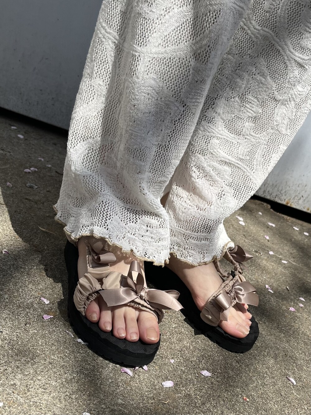 ホワイト系のチュニック、ホワイト系のその他パンツ、ベージュ系のサンダルを着用したレディースの春コーディネートの4枚目の写真