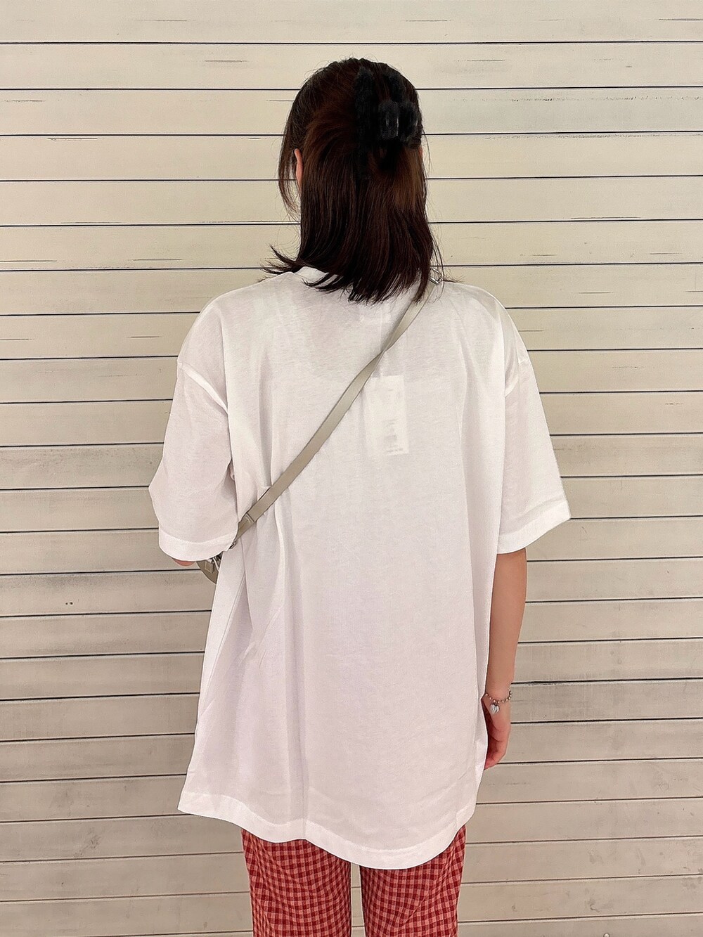 ホワイト系のTシャツ/カットソー、ゴールド系のショルダーバッグ、レッド系のスラックスを着用したレディースの夏コーディネートの4枚目の写真