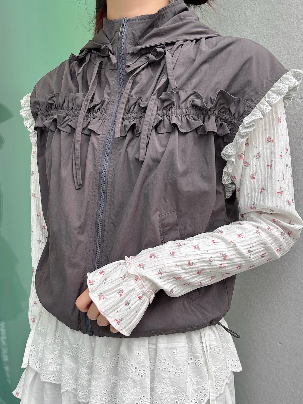 グレー系のベスト、ピンク系のTシャツ/カットソー、グレー系のスウェットパンツを着用したレディースの秋コーディネートの5枚目の写真