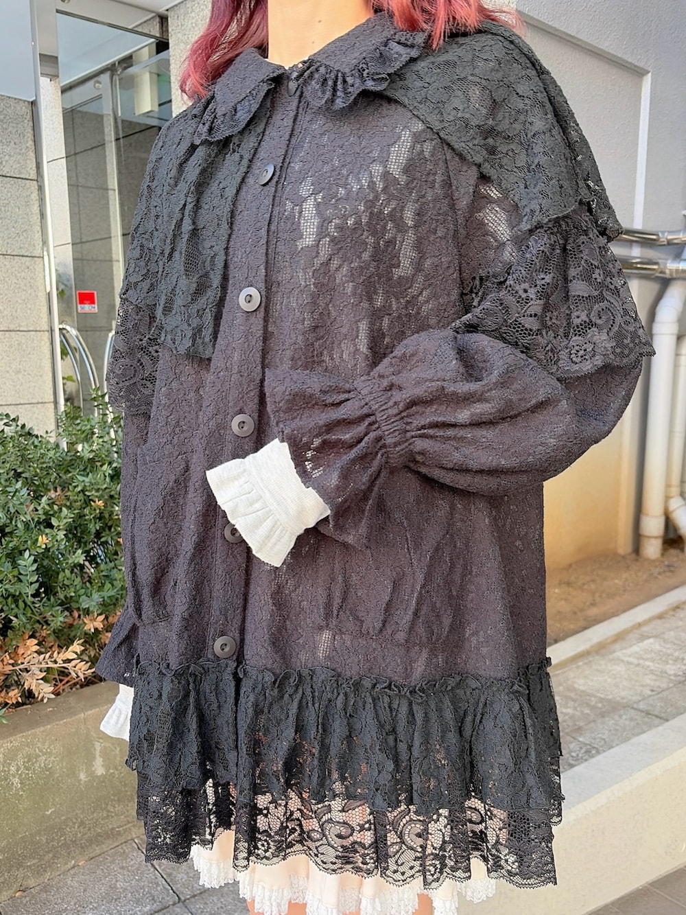 ブラック系のテーラードジャケット、ピンク系のスカート、ブラック系のスニーカーを着用したレディースの冬コーディネートの5枚目の写真