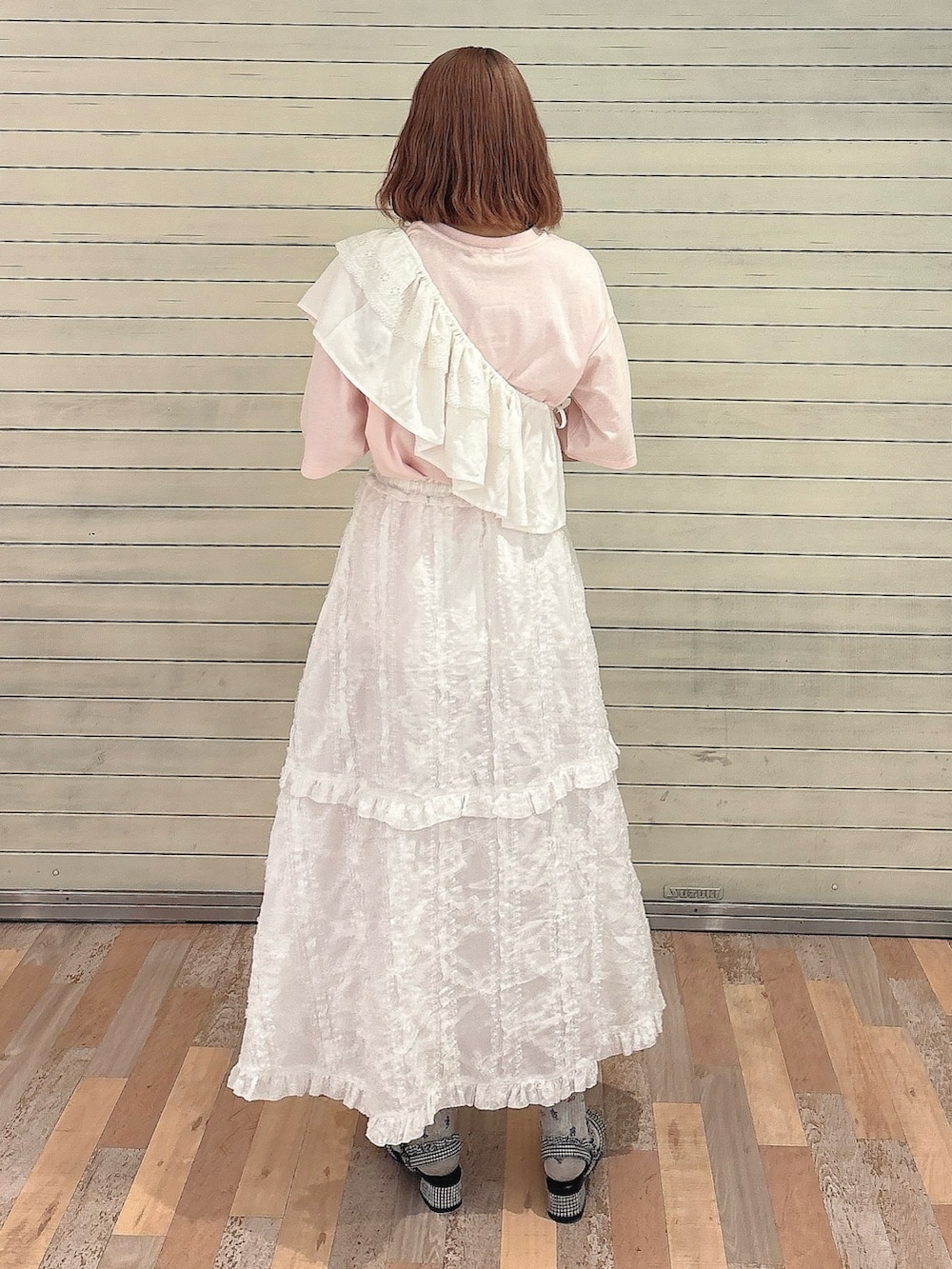 ホワイト系のスカート、ピンク系のTシャツ/カットソー、ブラック系のサンダルを着用したレディースの夏コーディネートの2枚目の写真