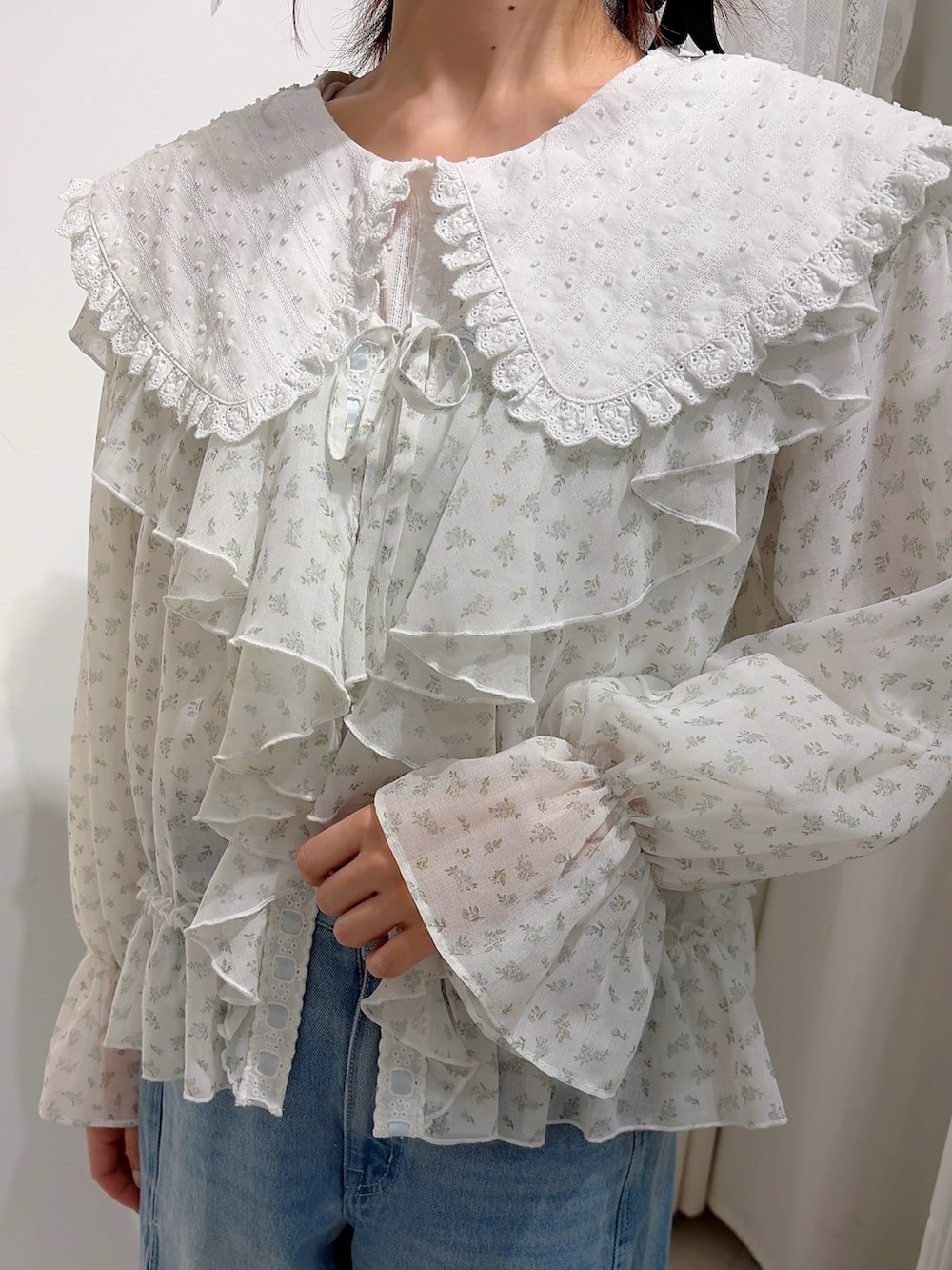 ホワイト系のシャツ/ブラウス、ブルー系のカーディガン/ボレロ、ブルー系のデニムパンツを着用したレディースの冬コーディネートの5枚目の写真