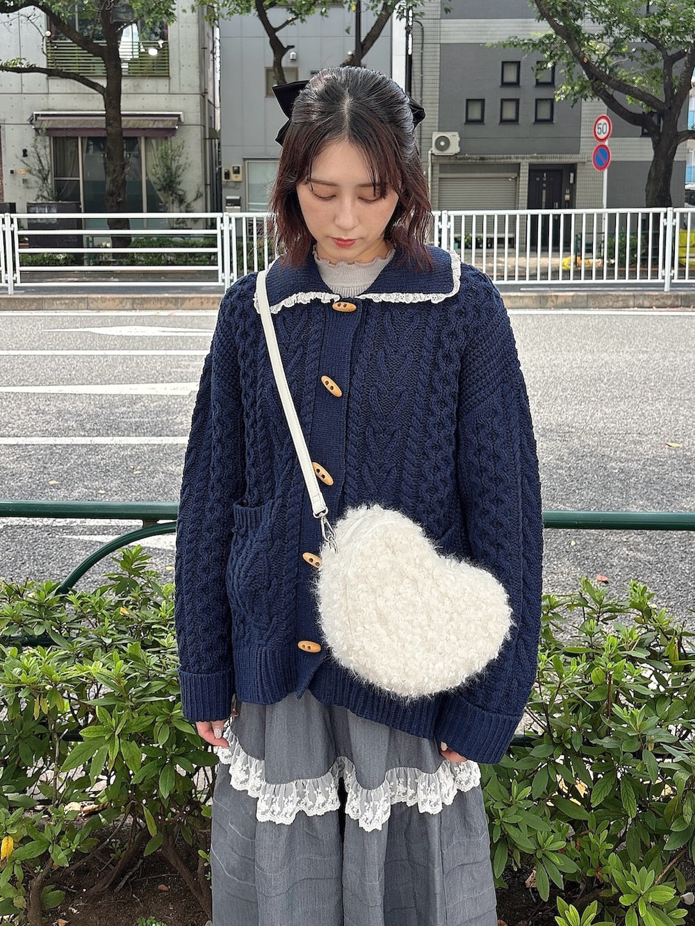 グレー系のスカート、ブルー系のカーディガン/ボレロ、ホワイト系のショルダーバッグを着用したレディースの夏コーディネートの3枚目の写真