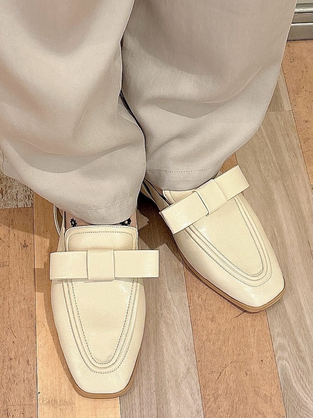 グレー系のスラックス、ホワイト系のローファー、ホワイト系のTシャツ/カットソーを着用したレディースの夏コーディネートの7枚目の写真