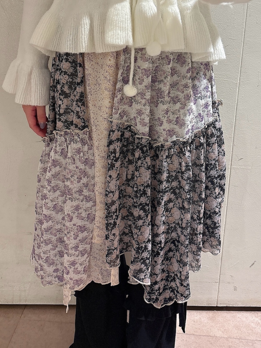 ホワイト系のニット/セーター、ブラック系のスカート、ブラック系のスウェットパンツを着用したレディースの秋コーディネートの6枚目の写真