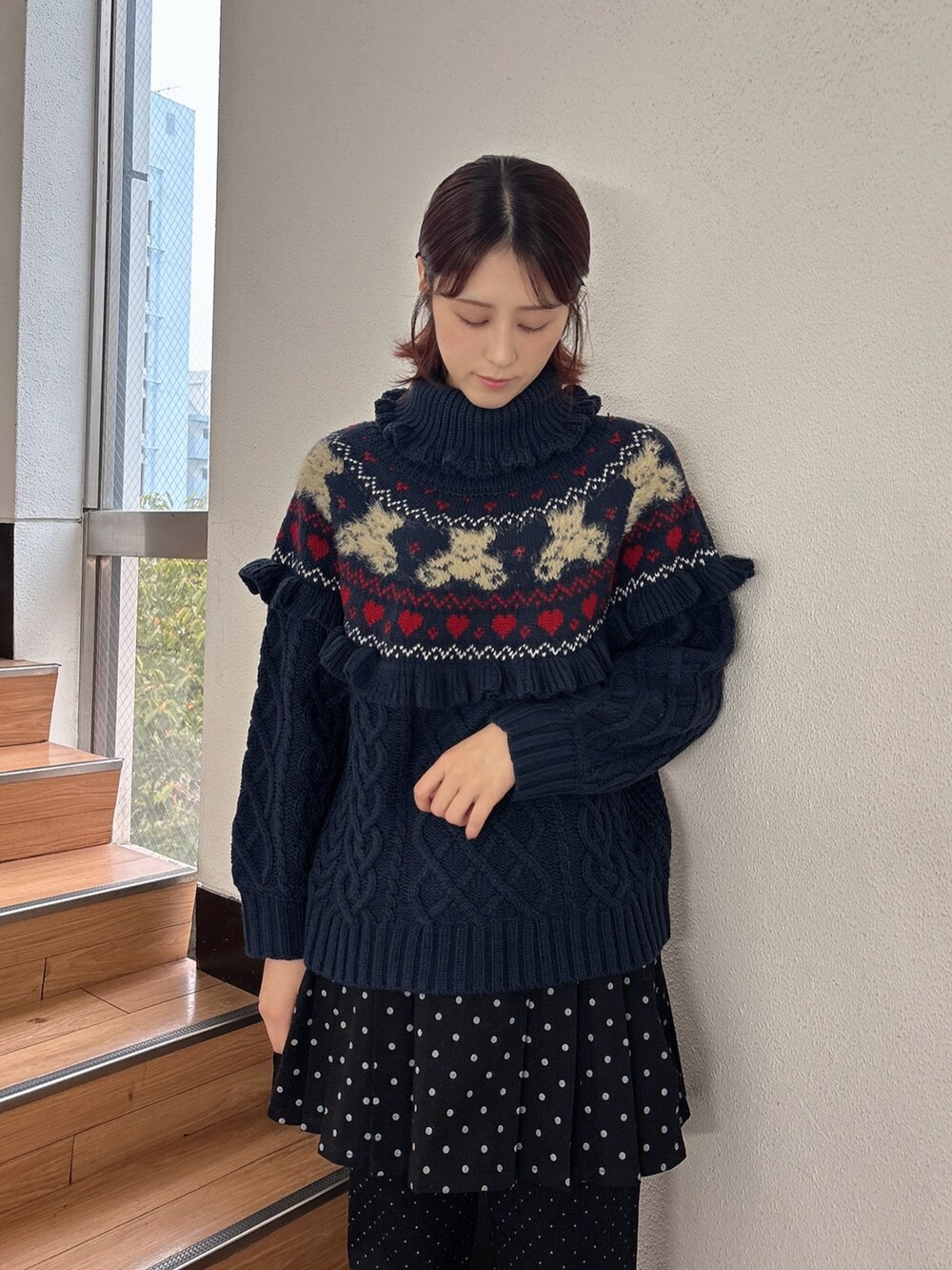 ブルー系のニット/セーター、ブラック系のスラックス、ブラック系のスカートを着用したレディースの秋コーディネートの3枚目の写真