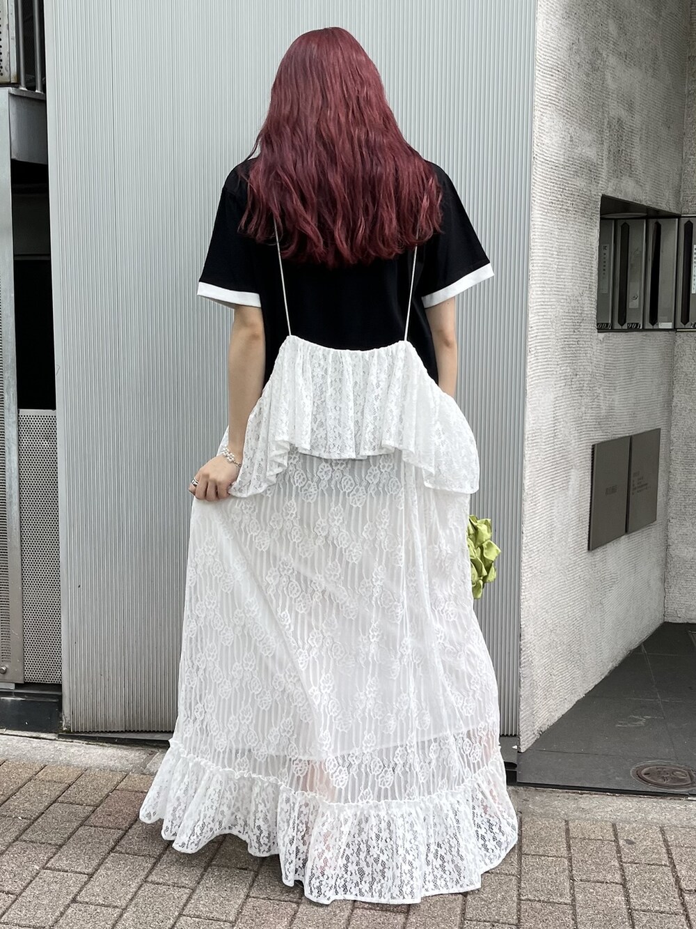 ブラウン系のサンダル、ホワイト系のスカート、ブラック系のTシャツ/カットソーを着用したレディースの春コーディネートの2枚目の写真