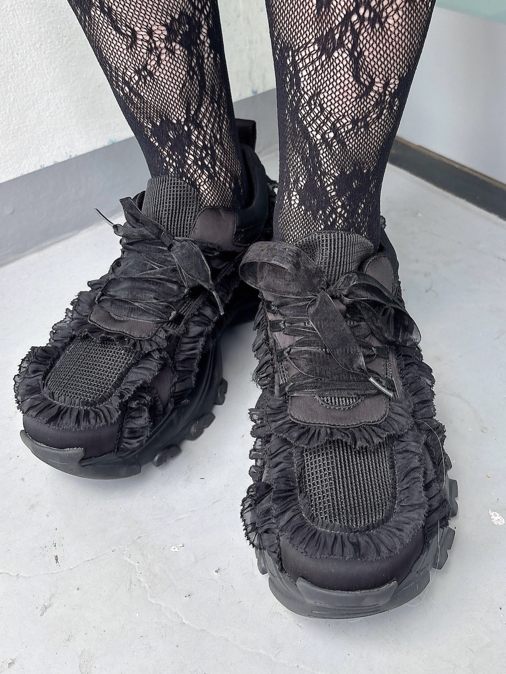 ブラック系のワンピース、ブラック系のスニーカー、ブラック系の付け襟を着用したレディースの春コーディネートの7枚目の写真