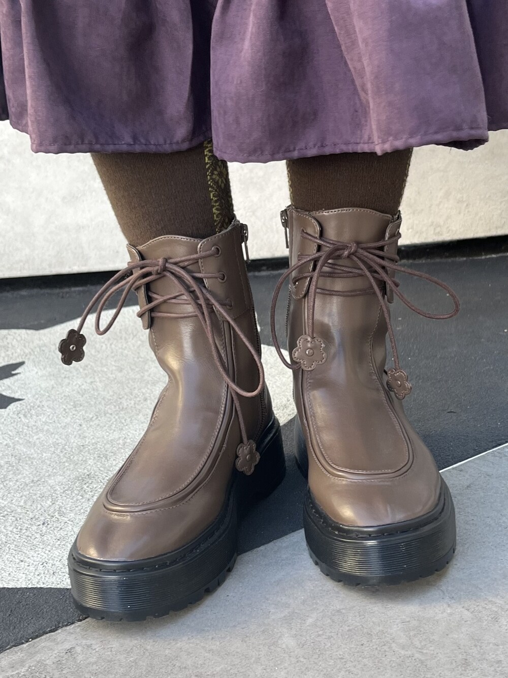 パープル系のワンピース、ブラウン系のブーツ、ブラック系のニット/セーターを着用したレディースの冬コーディネートの3枚目の写真